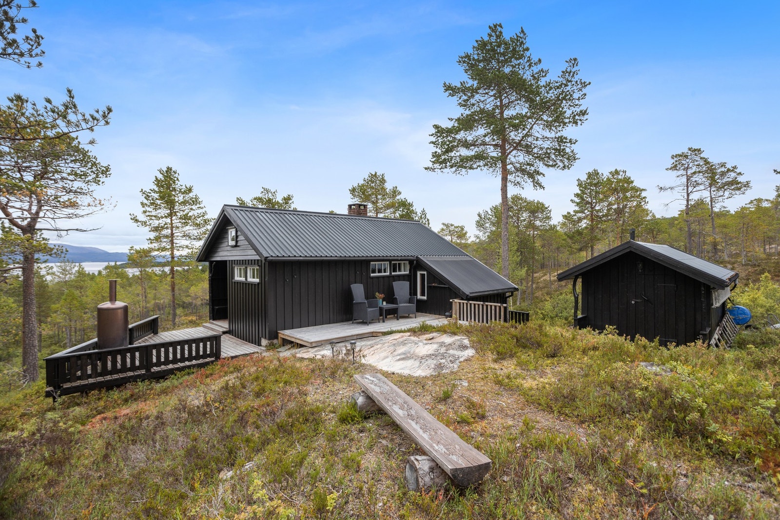 Sjarmerende hytte med terrasser og uthus. Galleribilde