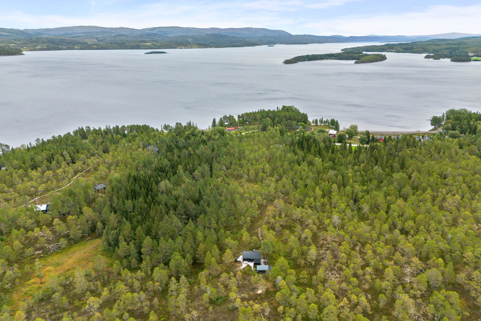 Hytta ligger fint på et høydedrag med utsikt utover skogen og Snåsavatnet. Skjermet beliggenhet. Galleribilde