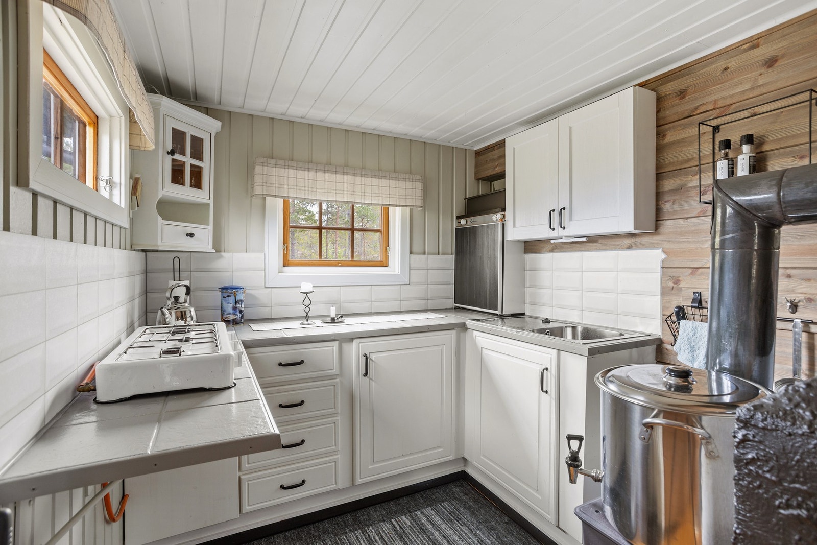 Kjøkkeninnredning med flislagt benkeplate. Etablert gasskjøleskap. Galleribilde