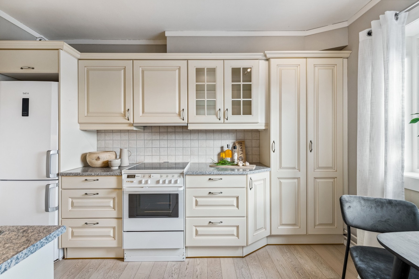 Pent kjøkken med profilerte fronter og benkeplate i stein Galleribilde