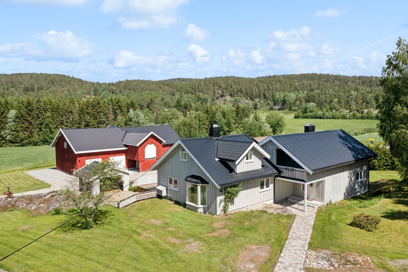 Her har man et koselig tun med enebolig, låve, stabbur og garasje Galleribilde