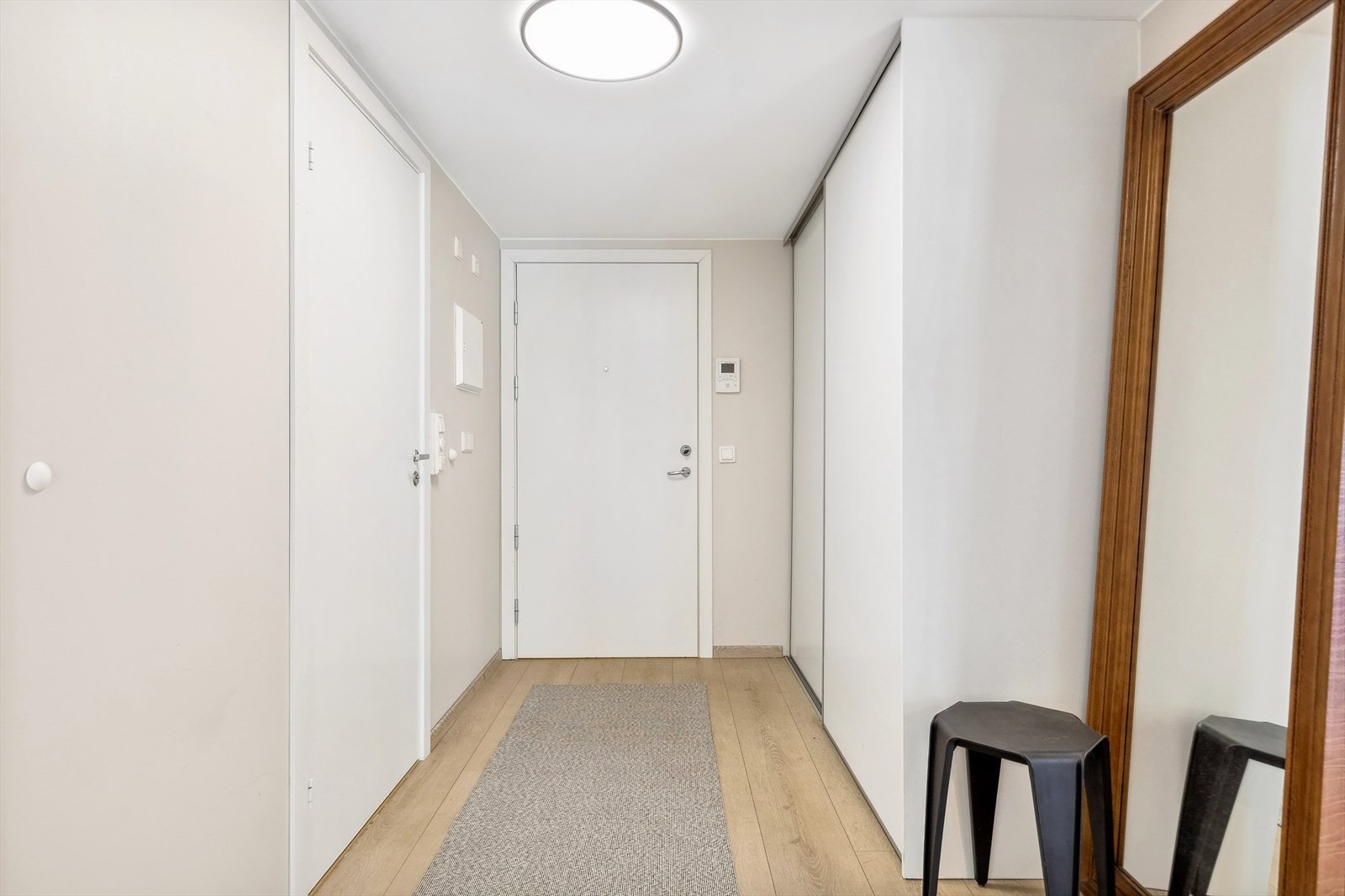 Leiligheten har en romslig entré med plass til å henge fra seg yttertøy og sette fra seg sko i stor skyvedørsgarderobe. Callinganlegg til høyre for inngangsdøren. Galleribilde