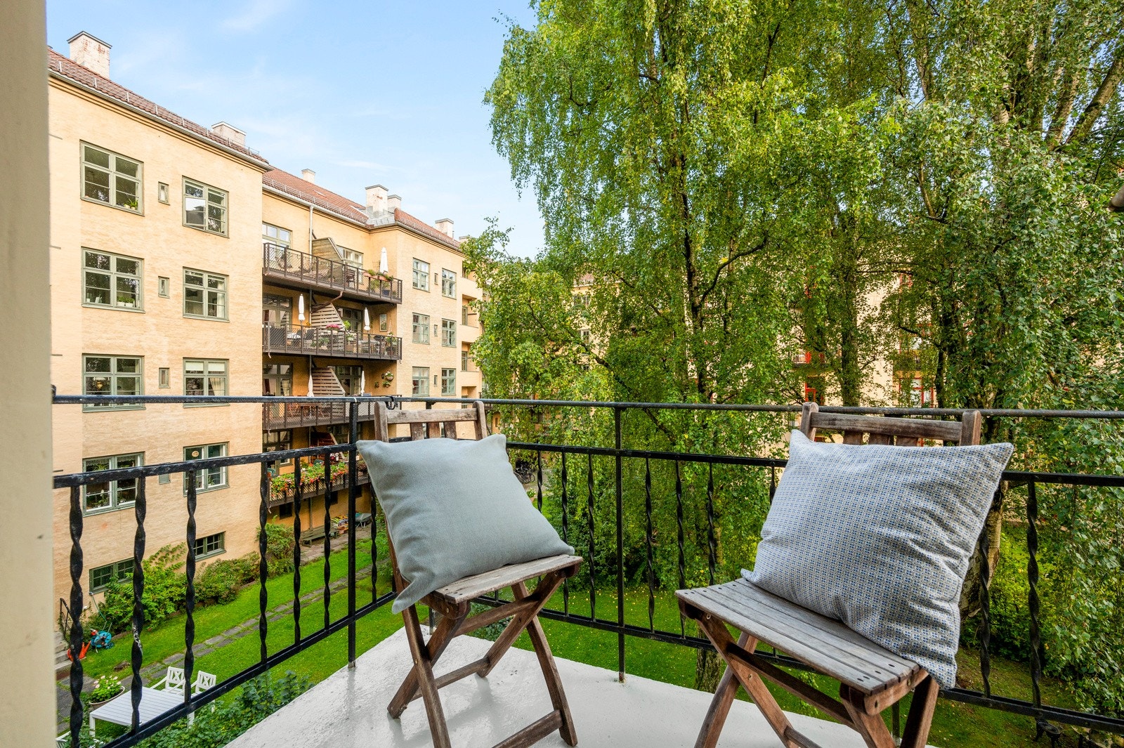 Via baktrappen finner du en felles balkong som vender ut mot en stort og idyllisk gårdsrom. Galleribilde