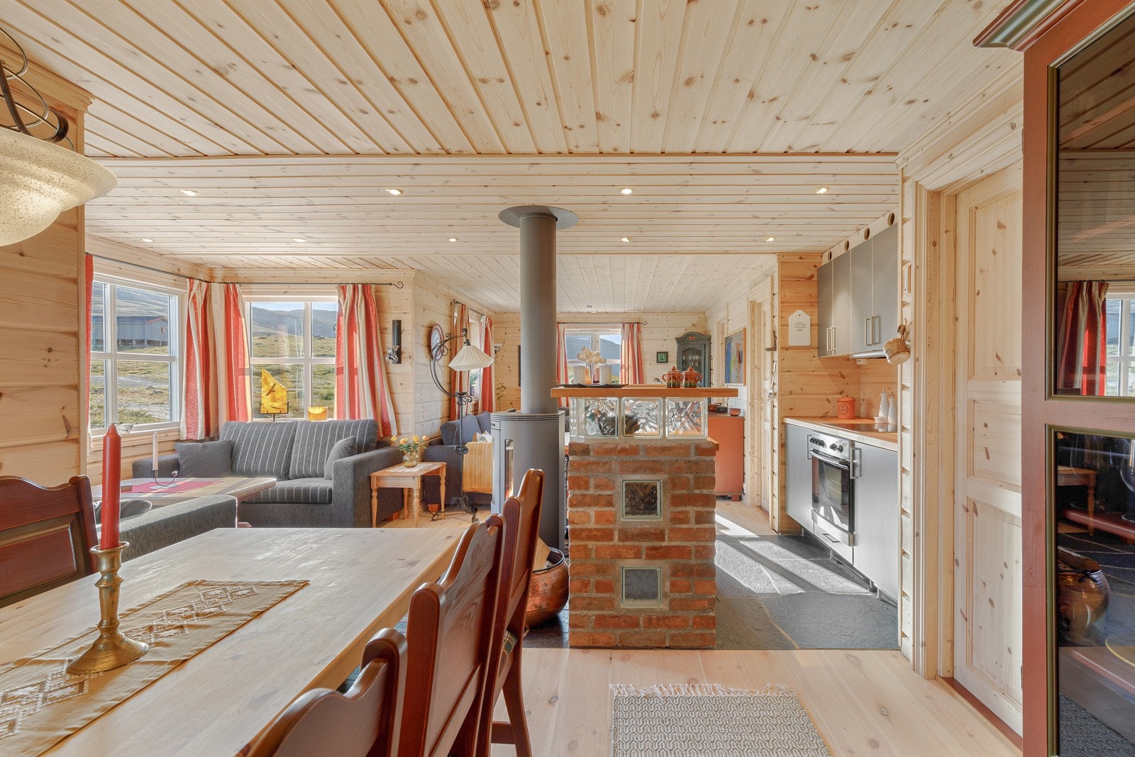 Vidare kjem du inn i resten av hytta. Her har du kjøken, spisebord og 2 sofasoner. Galleribilde