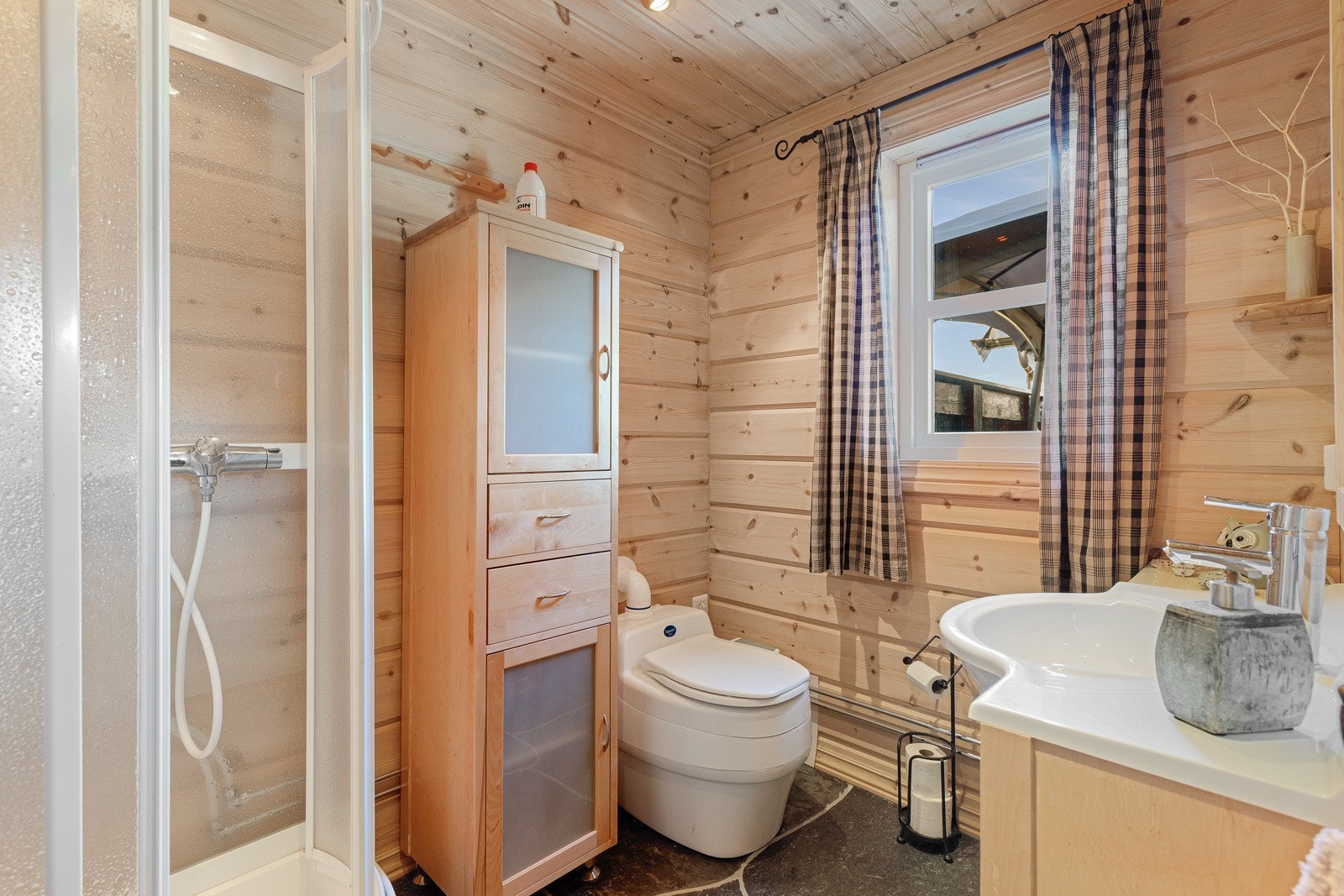 Badet har dusj og vask som kan nyttast med sommarvatn. Her har ein hyttetoalett. Galleribilde