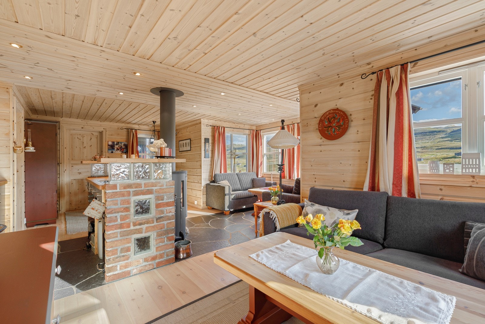 Åpen løysing mellom stove og kjøken, som samtidig er skjerma med halvveggar. Galleribilde