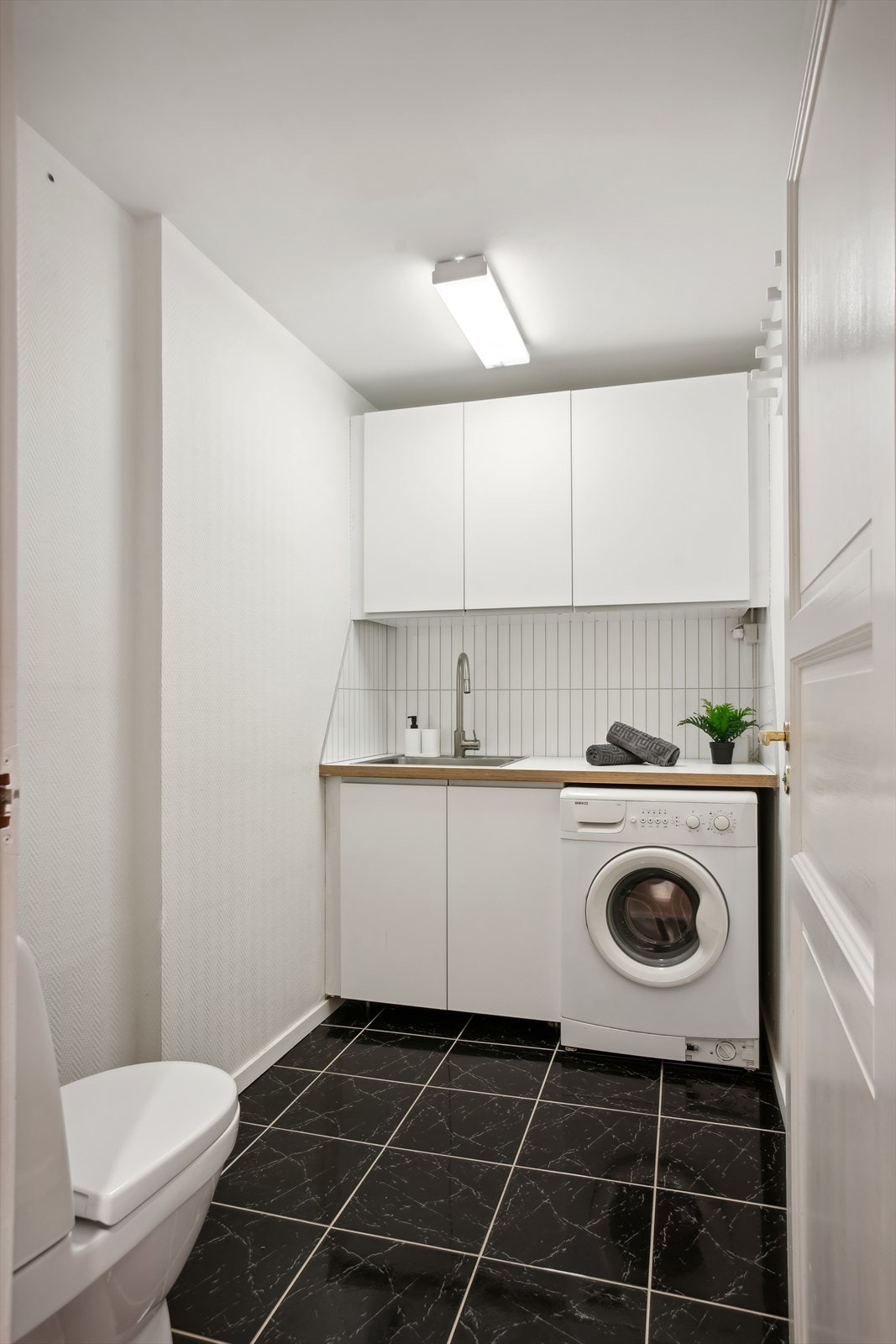 Toalettrom/vaskerom har fliser på gulv og strie på vegger. Innvendig tak med malte flater. Galleribilde