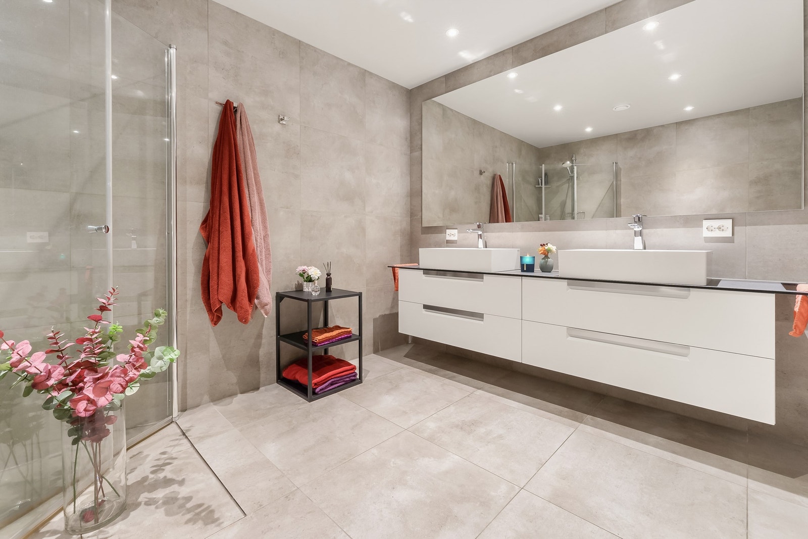 Badet er lekkert og moderne, med 60x60cm flis med samme fargetone på både golv og vegg, stort speil og dobbel servant Galleribilde
