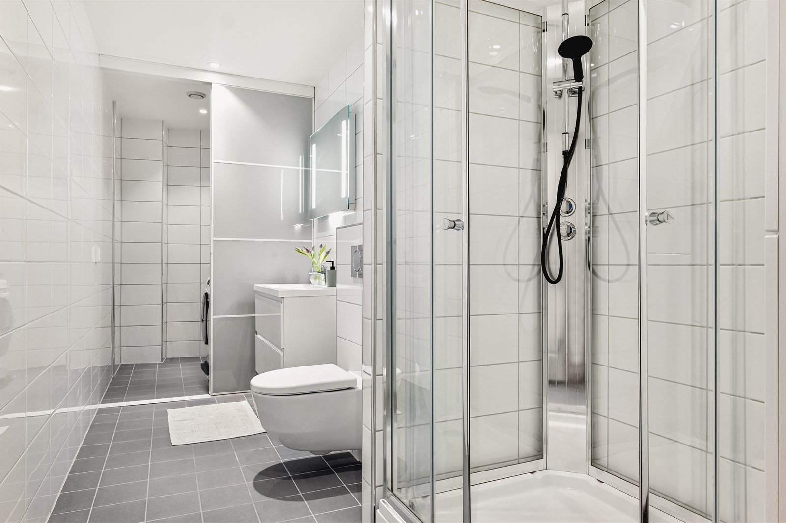 Romslig bad med delikat baderomsinnredning. Legg merke til praktiske skyvedøren som skjuler vaskemaskin/tørketrommel. Galleribilde