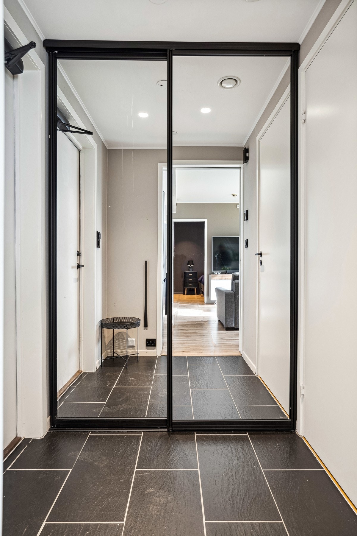 Flislagt entre med skyvedørsgarderobe. Galleribilde