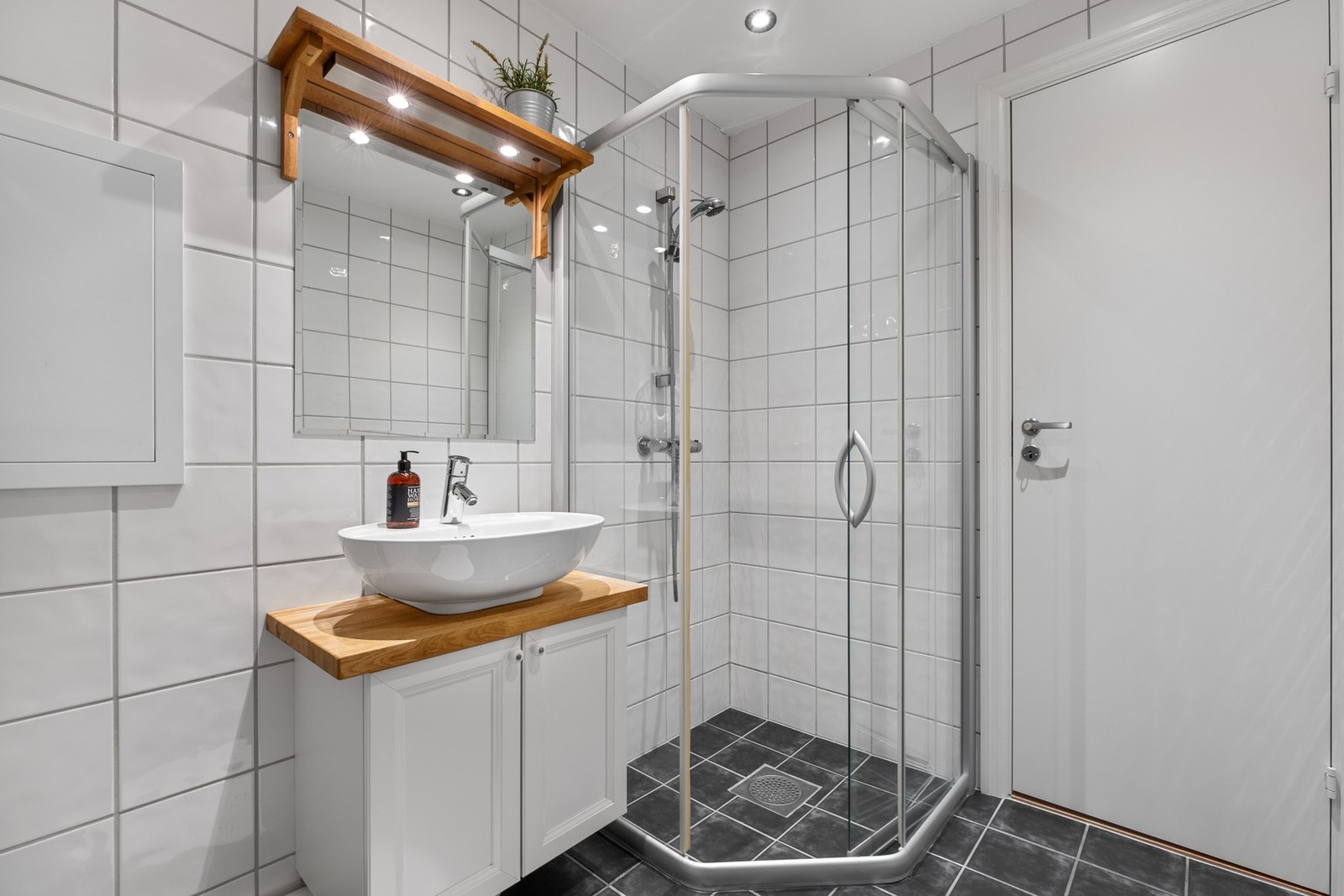 Badet er utstyrt med bl.a. klosett, dusjhjørne, servant og opplegg til vaskemaskin. Galleribilde