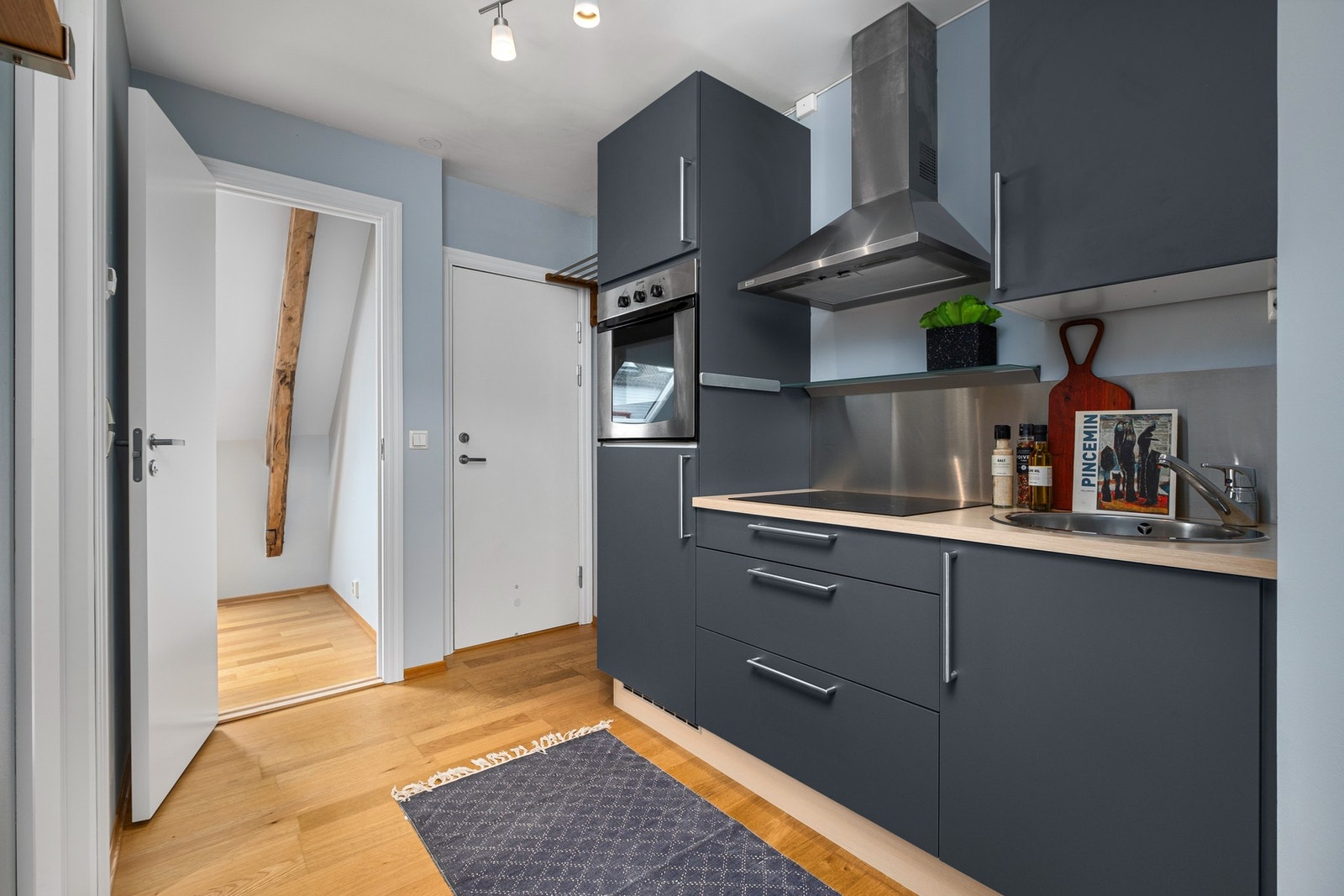 Pent kjøkken som har plane fronter og heltre laminert benkeplate. Galleribilde