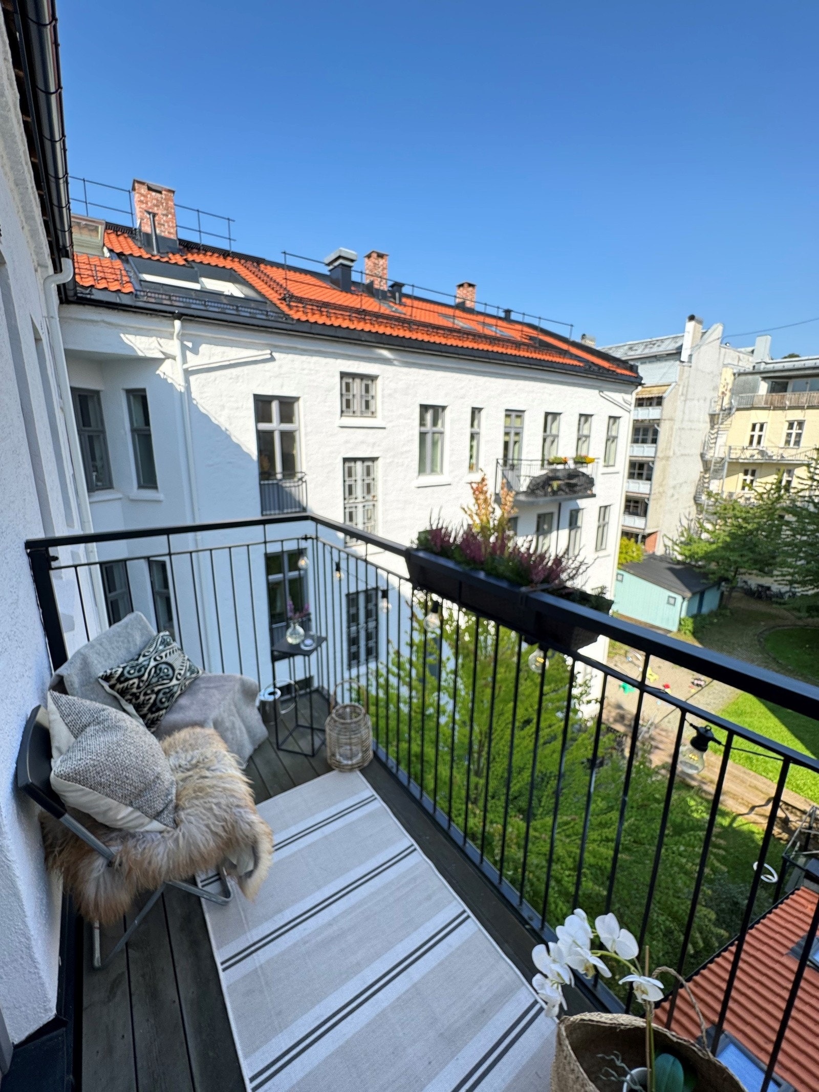 Balkong mot grønn og trivelig bakgård. Galleribilde