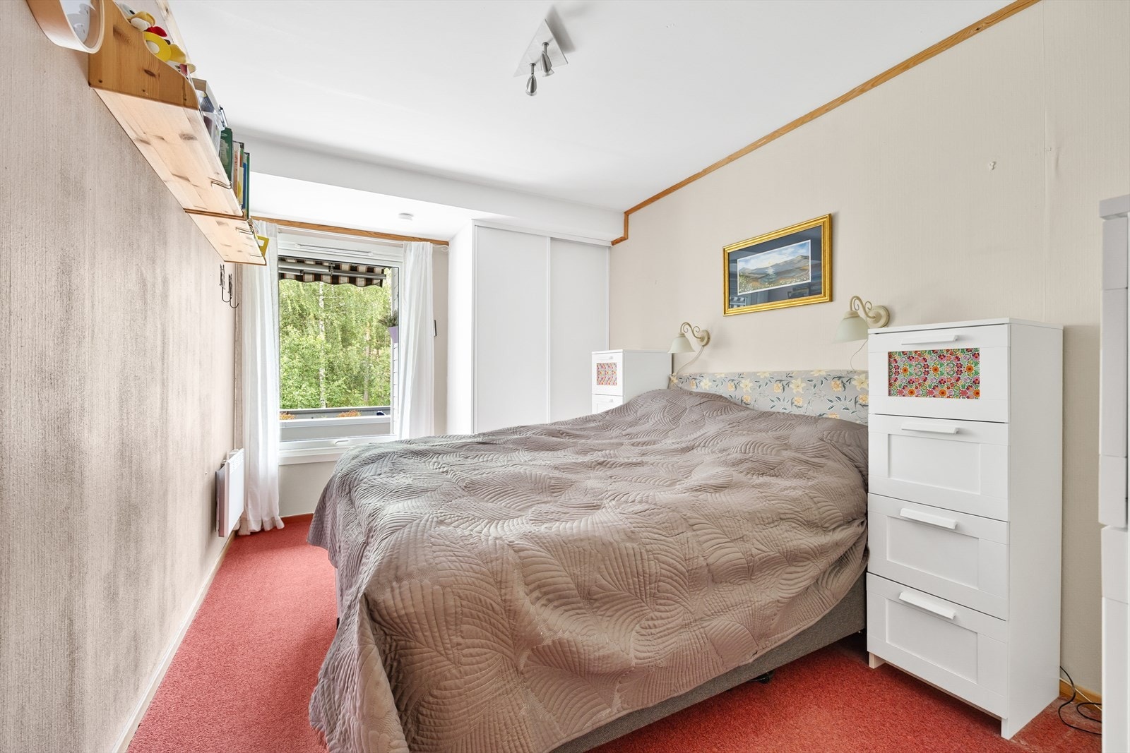 Leiligheten har ett romslig soverom med teppe på gulvet Galleribilde