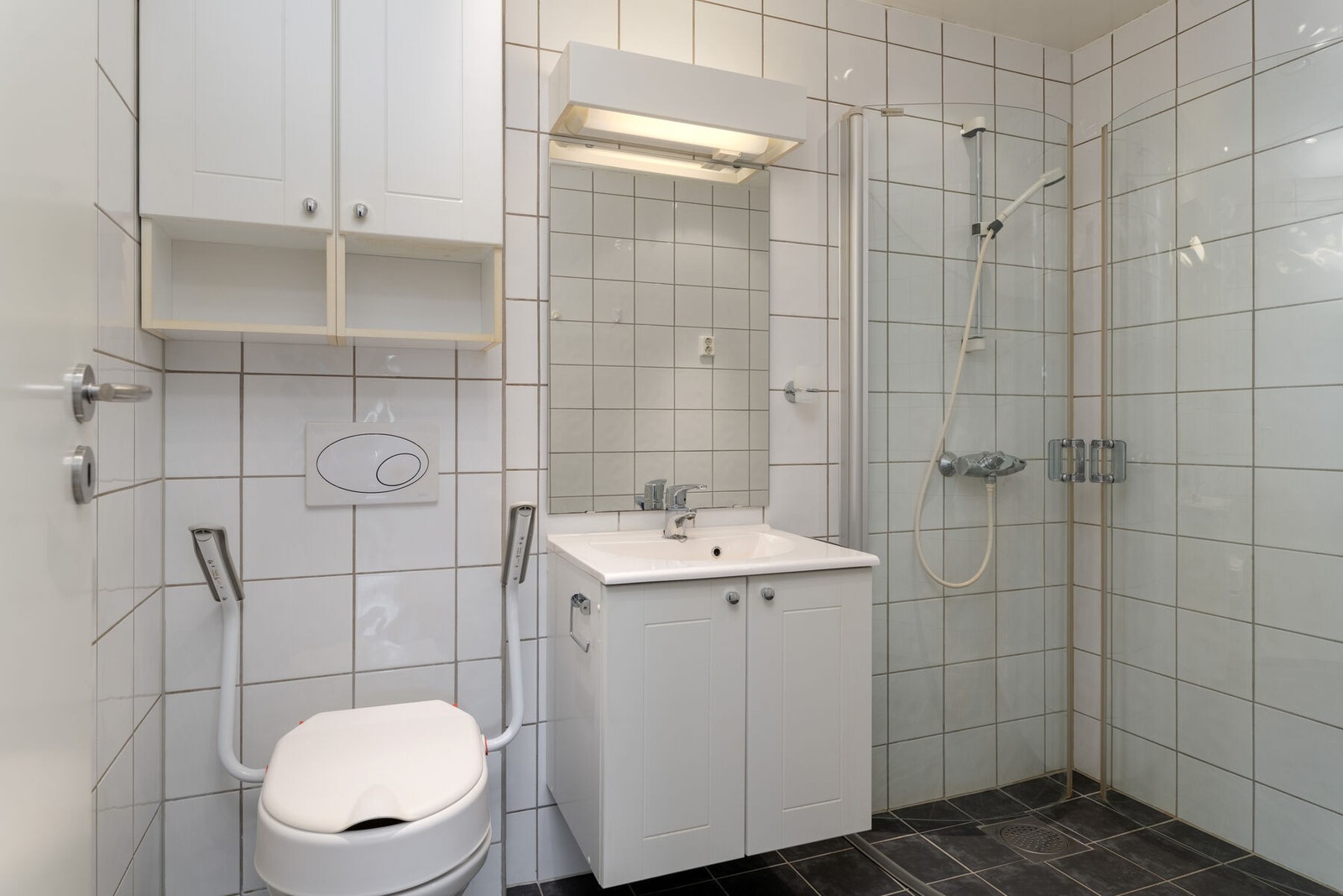 Badet har innredning med servant, toalett, dusjhjørne og opplegg for vaskemaskin. Galleribilde