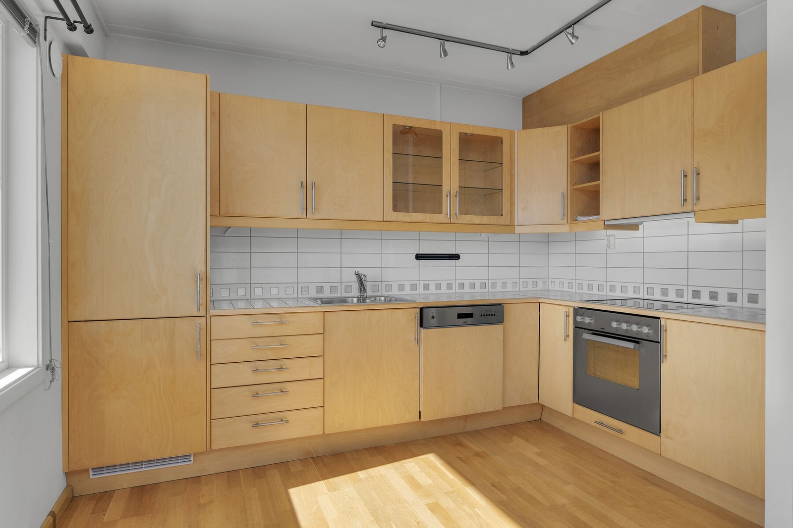 Kjøkkeninnredning med slette fronter og flisbelagt benkeplate. Galleribilde