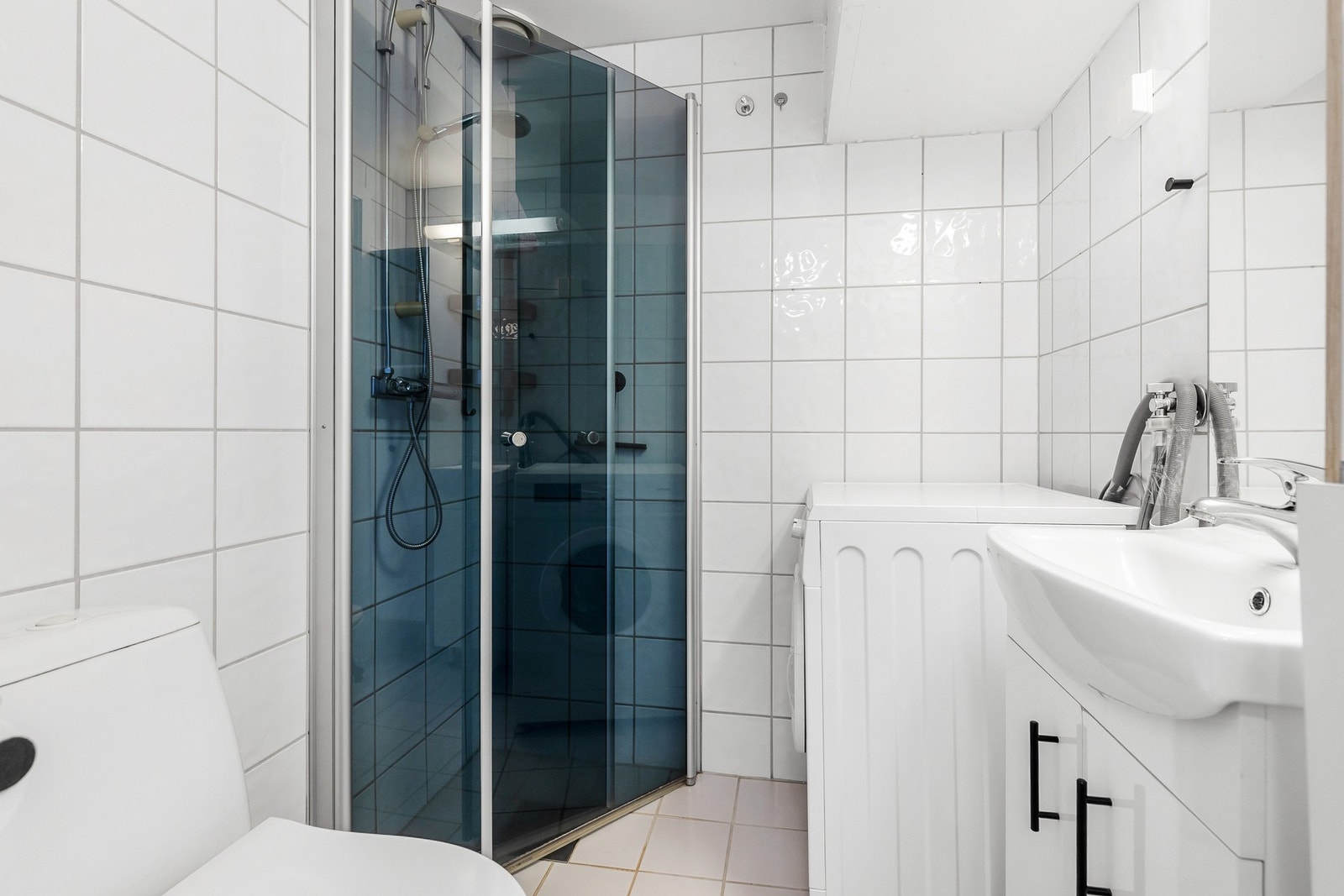 Flislagt bad med gulvvarme og opplegg for vaskemaskin Galleribilde