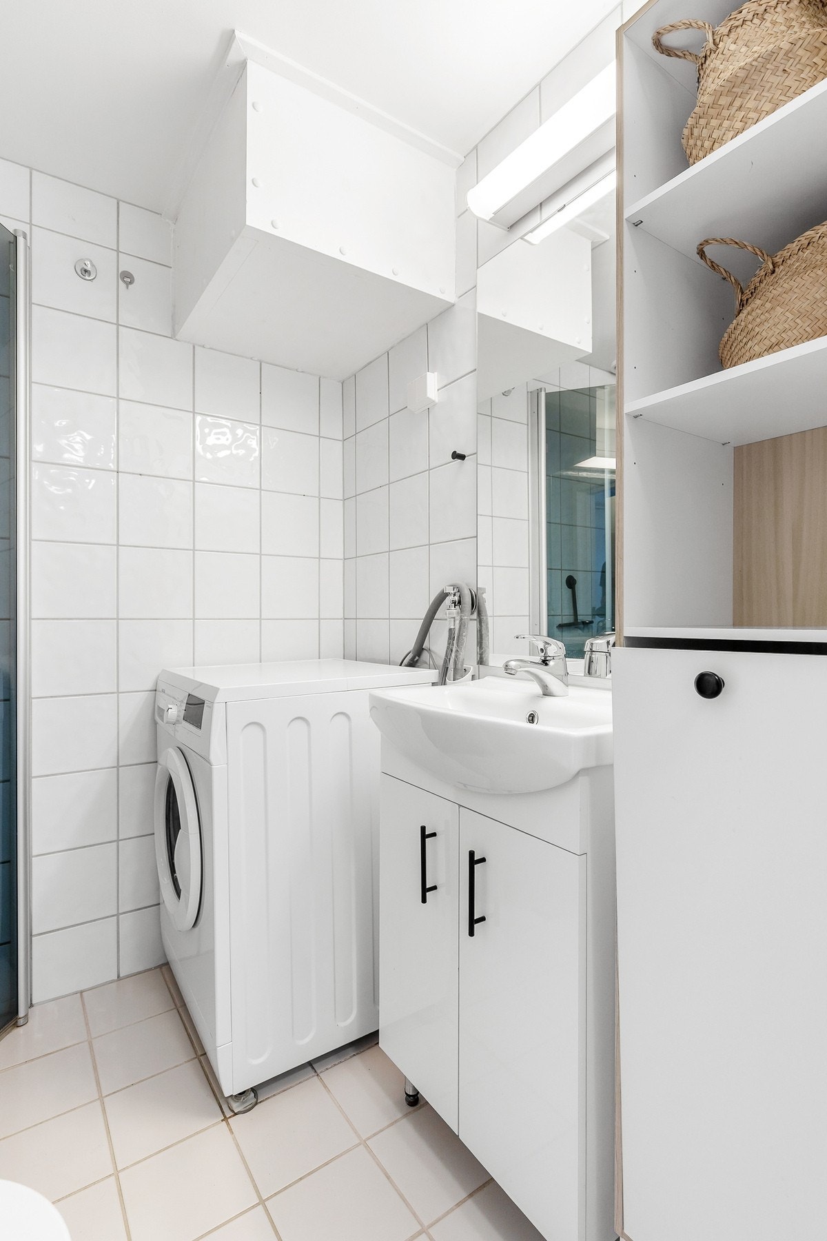 Badet er innredet med dusjhjørne, servantinnredning og gulvstående toalett Galleribilde