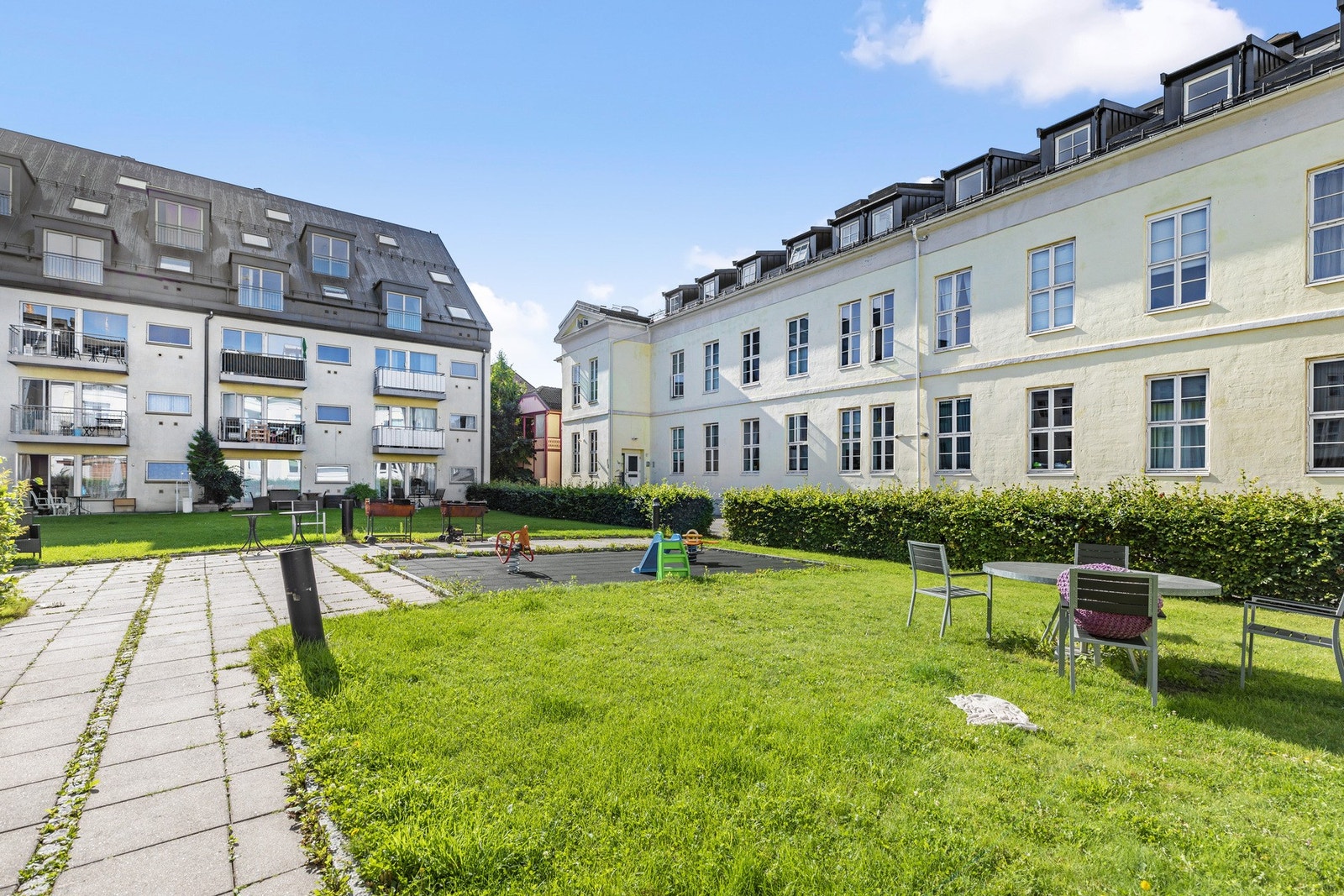 Pent opparbeidet fellesareal med lekeplass, sittegrupper, plen og beplantning Galleribilde