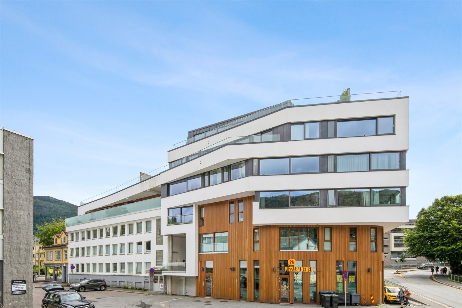 Velkommen til Eikeveien 4. Inngang ved stoppskiltet midt på bygget. Leiligheten ligger i venstre del. Galleribilde