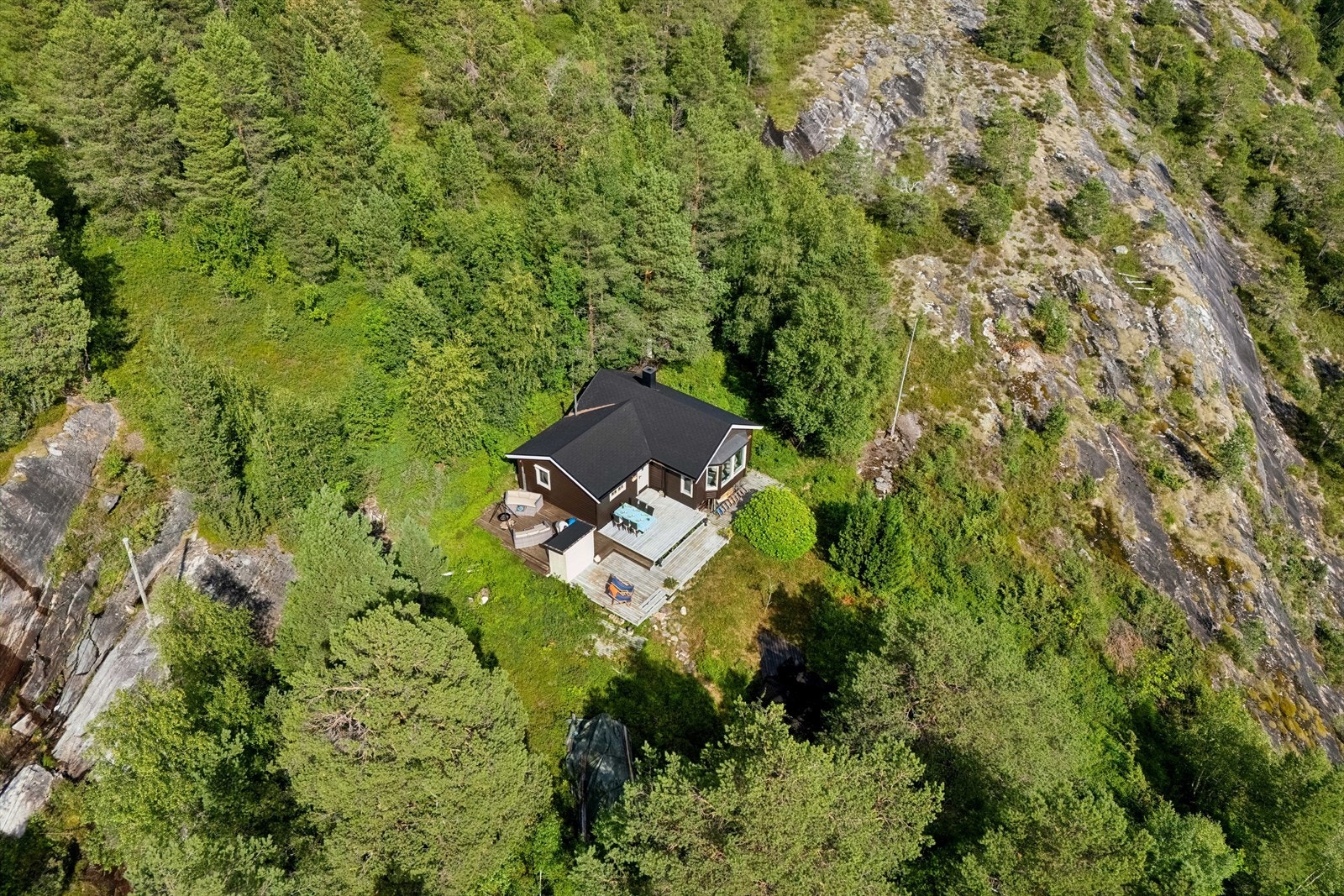 Tomten fremgår i hovedsak som naturtomt, men er noe ryddet rundt selve hytten Galleribilde