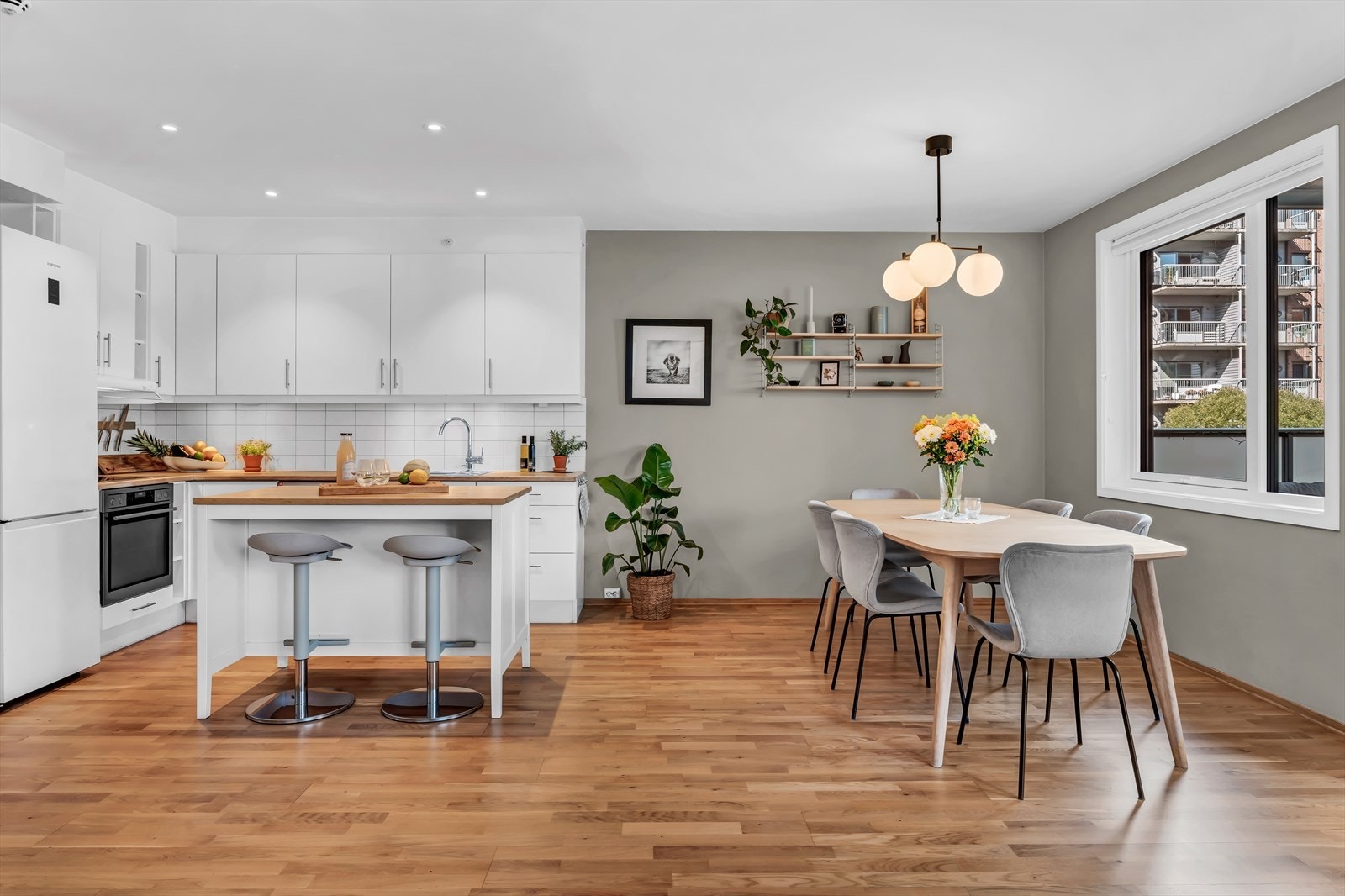 Kjøkkeninnredning med glatte fronter og fliser vegg over benkeskap og frittstående kjøkkenøy fra IKEA Galleribilde