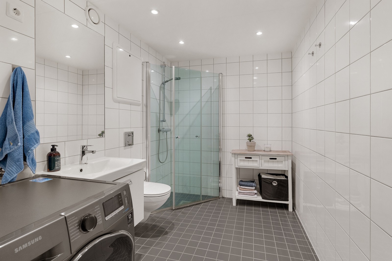 Delikat, flislagt bad med praktisk downlight belysning i tak. Galleribilde