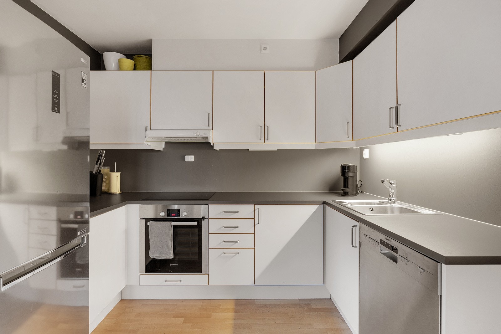 Kjøkkenet har slette lakkerte fronter med eikekant og laminat benkeplate. Galleribilde