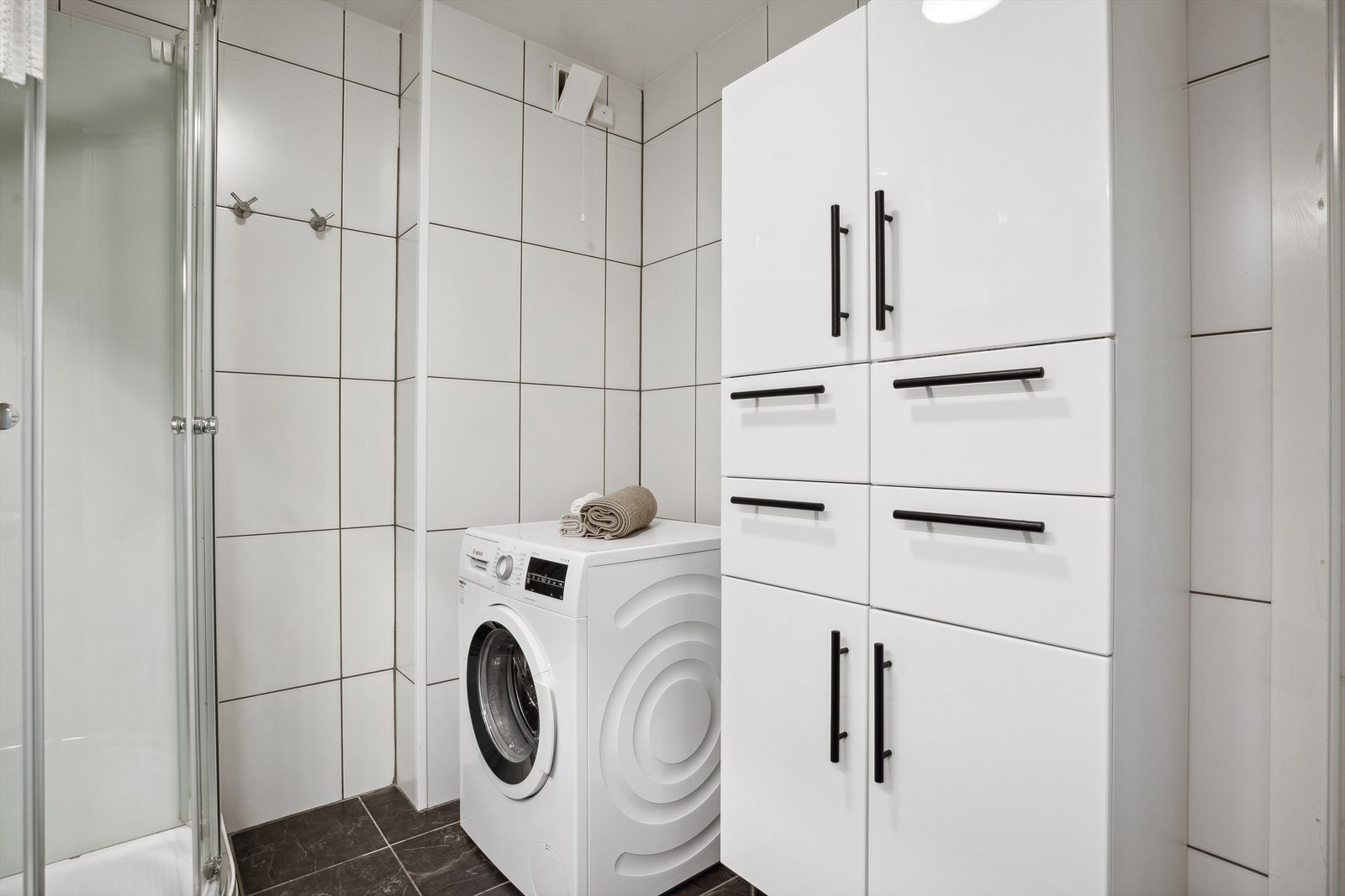 Baderommet har dusjkabinett, innredning med servant samt opplegg for vaskemaskin. Galleribilde