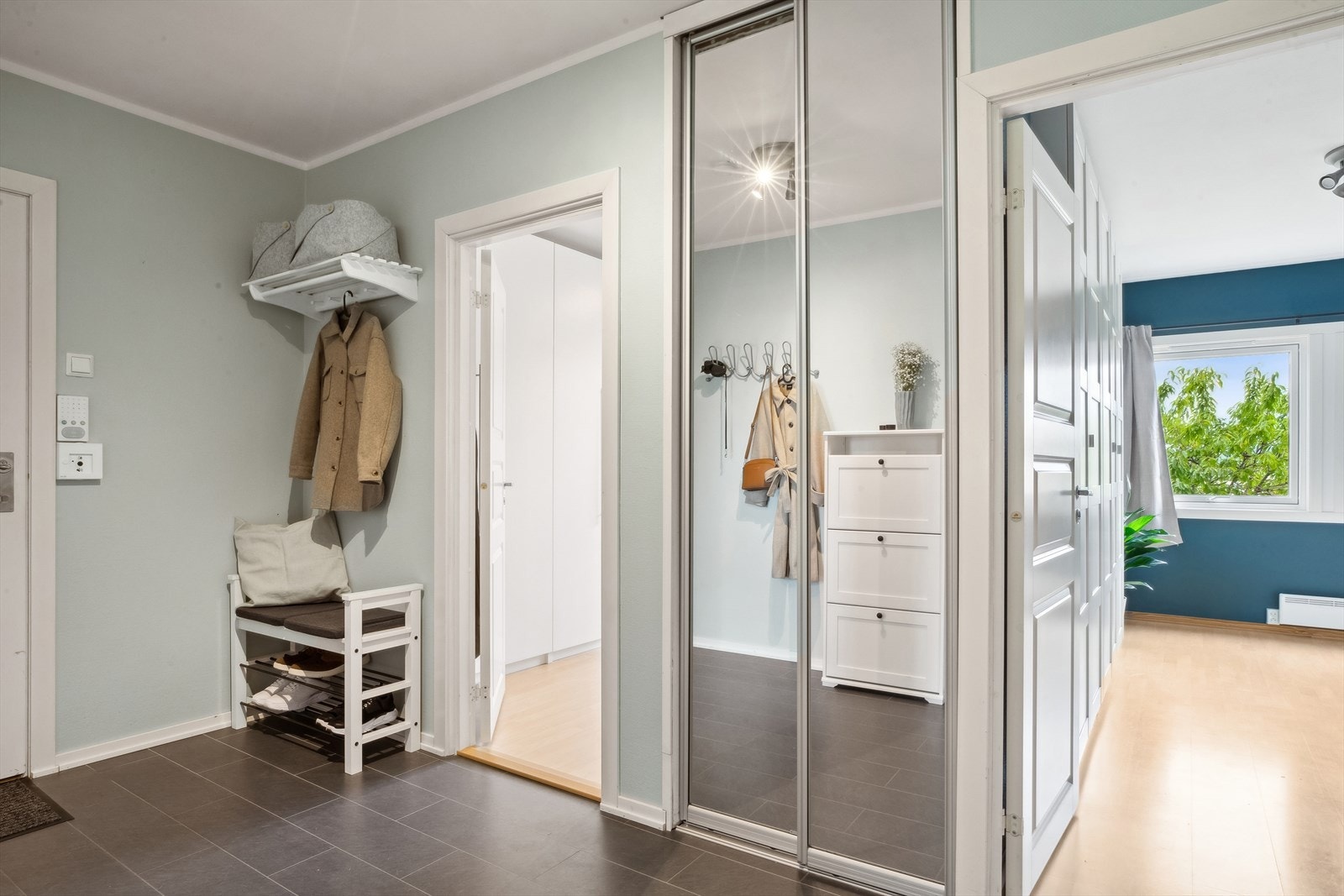 Entréen er ca 7,9 m² og har smart plassering av knaggrekke til yttertøy, skohylle samt et lite men praktisk garderobeskap med speilfronter. Galleribilde