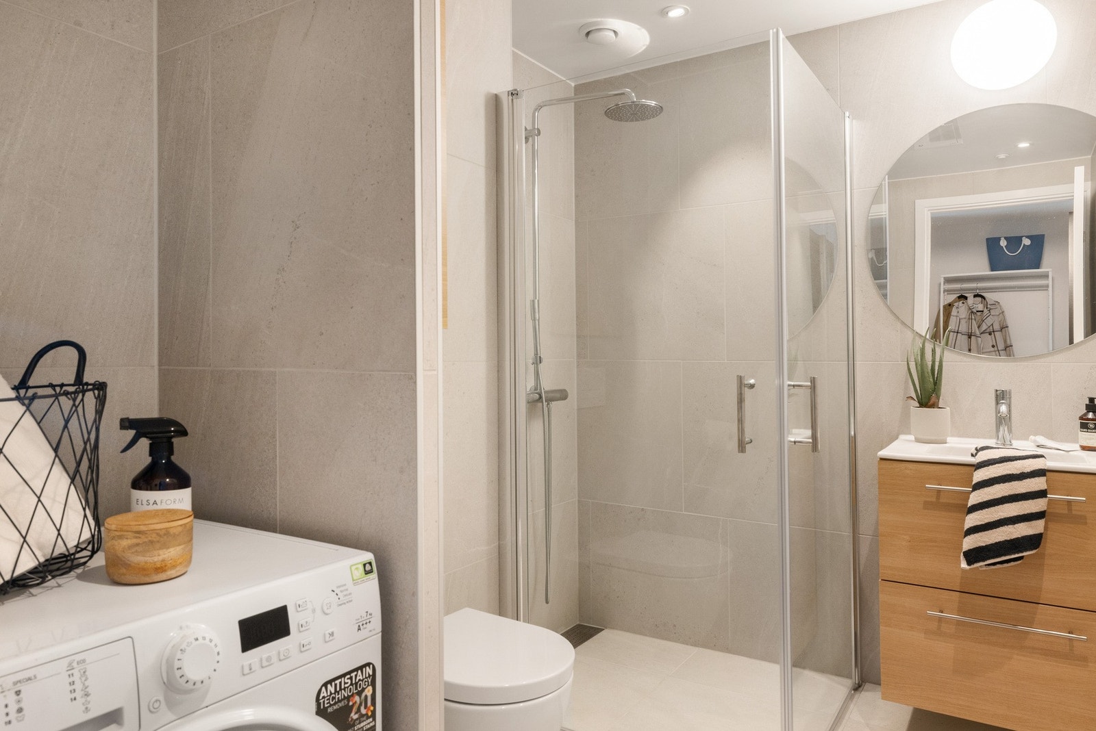 Lekkert og moderne bad, med opplegg for vaskemaskin og tørketrommel. Galleribilde
