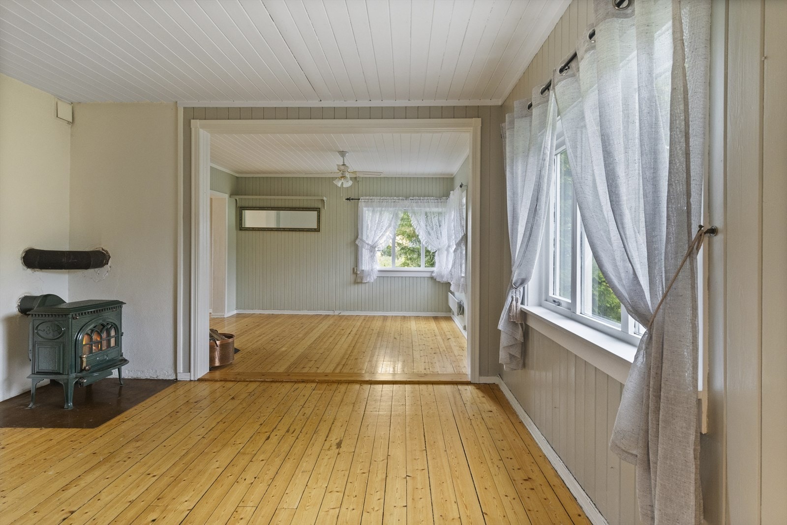 Spisestuen og stuen i åpen løsning, har malt panel på vegg og i himling. Behandlet tre på gulv. Galleribilde