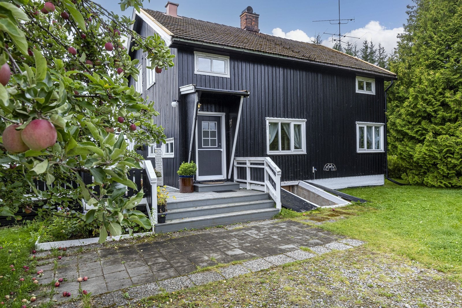 Fasade ved inngang, steinheller foran trapp opp til terrasse. Galleribilde