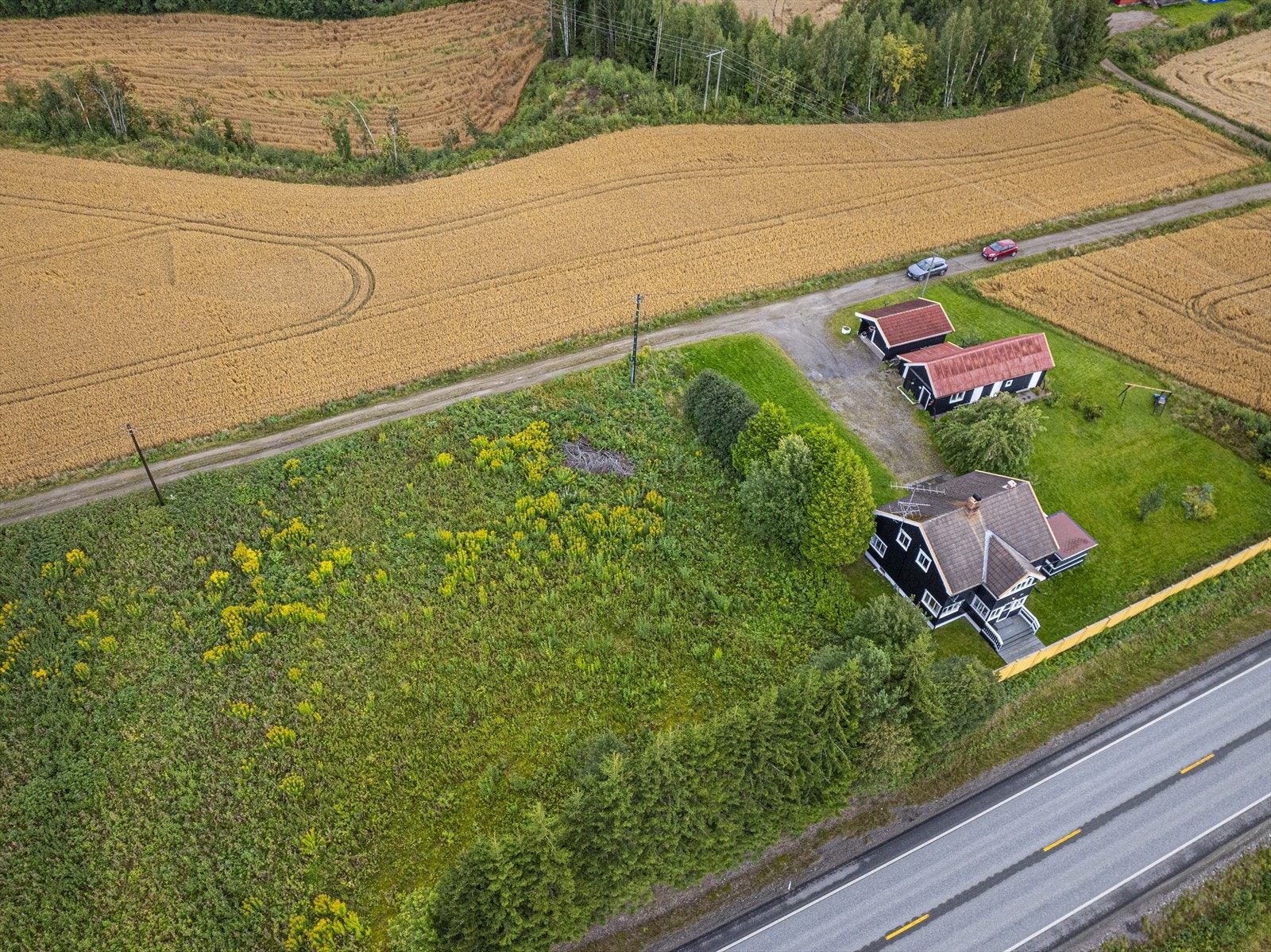 Oversiktsbilde av eiendommen med tilleggs tomt som har flere bruksmuligheter, er delvis skjermet med trær mot Solørvegen. Galleribilde