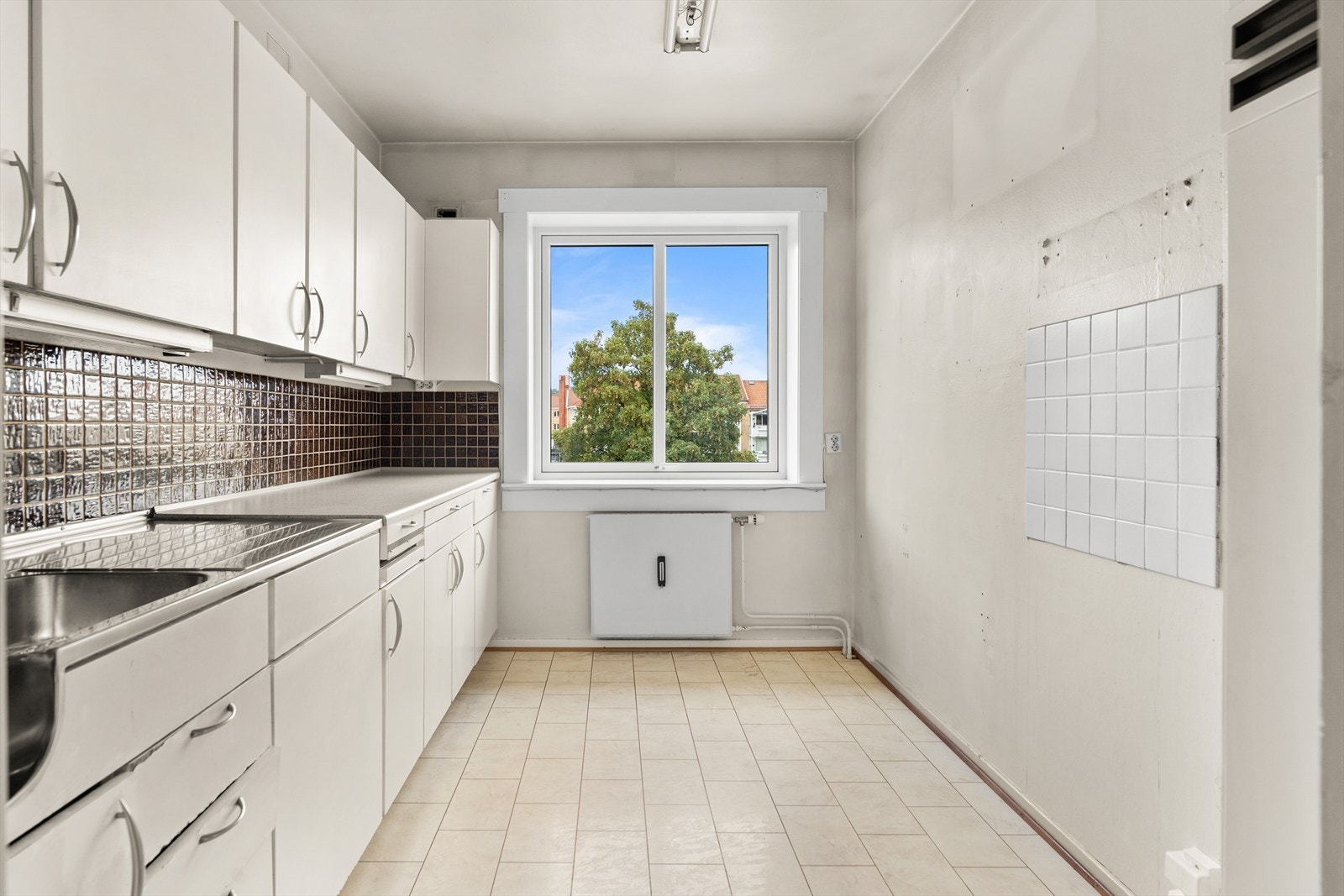 Separat kjøkken med vindu og utsikt til nærområde Galleribilde