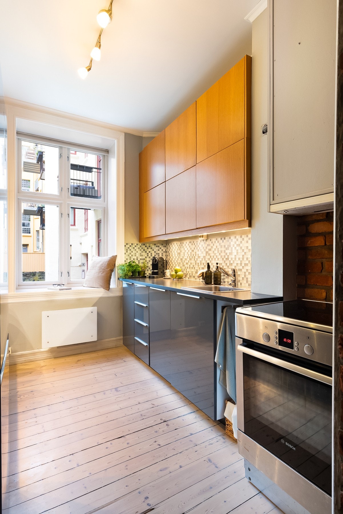 Leiligheten har et lunt og hyggelig, separat kjøkken med mye skap- og benkeplass. Kjøkkeninnredningen er en kombinasjon av IKEA Ringhult Dark Grey og Sigdal trehvit. Galleribilde