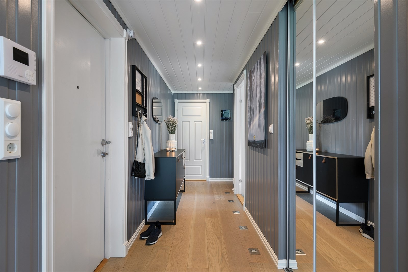 Inngangspartiet er romslig med god plass til å ta av sko og yttertøy. Det er også en stor skyvedørsgarderobe her. I tillegg er det belysning i gulvet. Galleribilde