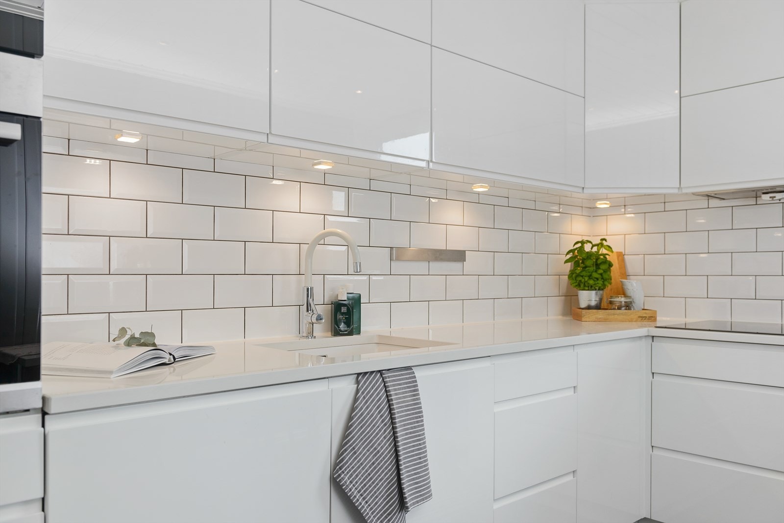 Integrert steikeovn, platetopp, kaffemaskin og oppvaskmaskin. Godt med skap og skuffer. Fliser mellom over- og underskap. Frittstående kjøleskap medfølger handelen. Galleribilde