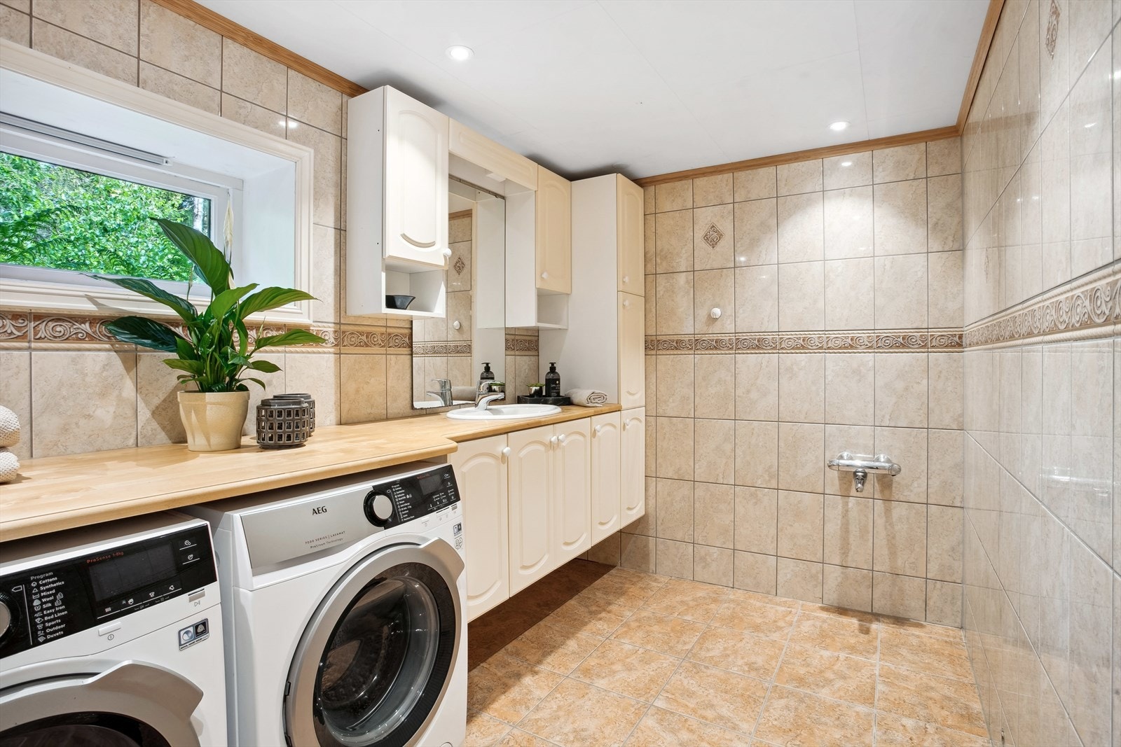 Badet er et kombinert bad/vaskerom og har opplegg for vaskemaskin og tørketrommel. Det er lagt opp opplegg og avsatt plass til å sette inn badekar her inne om man skulle ønske seg det. Galleribilde