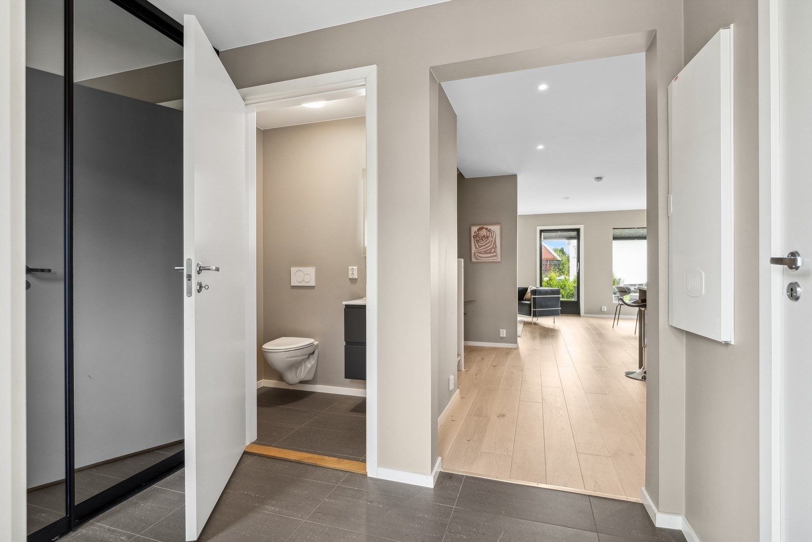 Fra entreen er det adkomst til gjestetoalett og stort vaskerom, også med gulv fliser med gulvvarme. Galleribilde