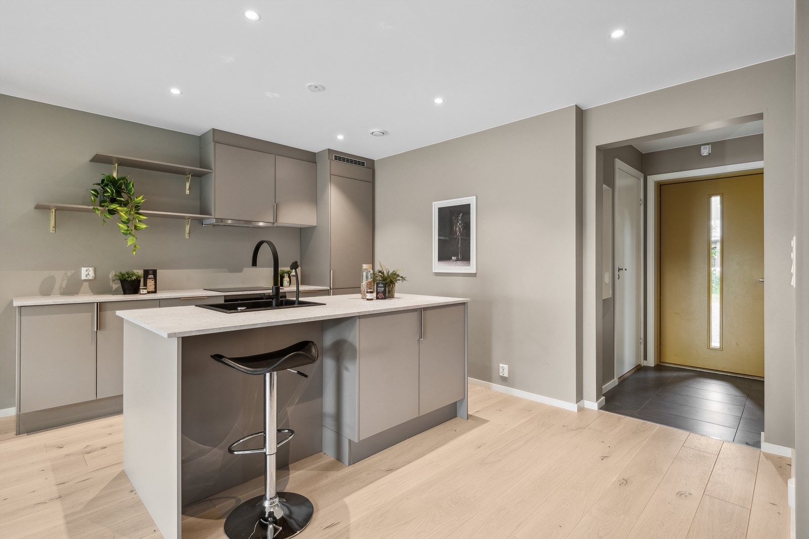 Kjøkkeninnredningen er moderne og har en stor kjøkkenøy med bar/sitteplass for et raskt frokostmåltid Galleribilde