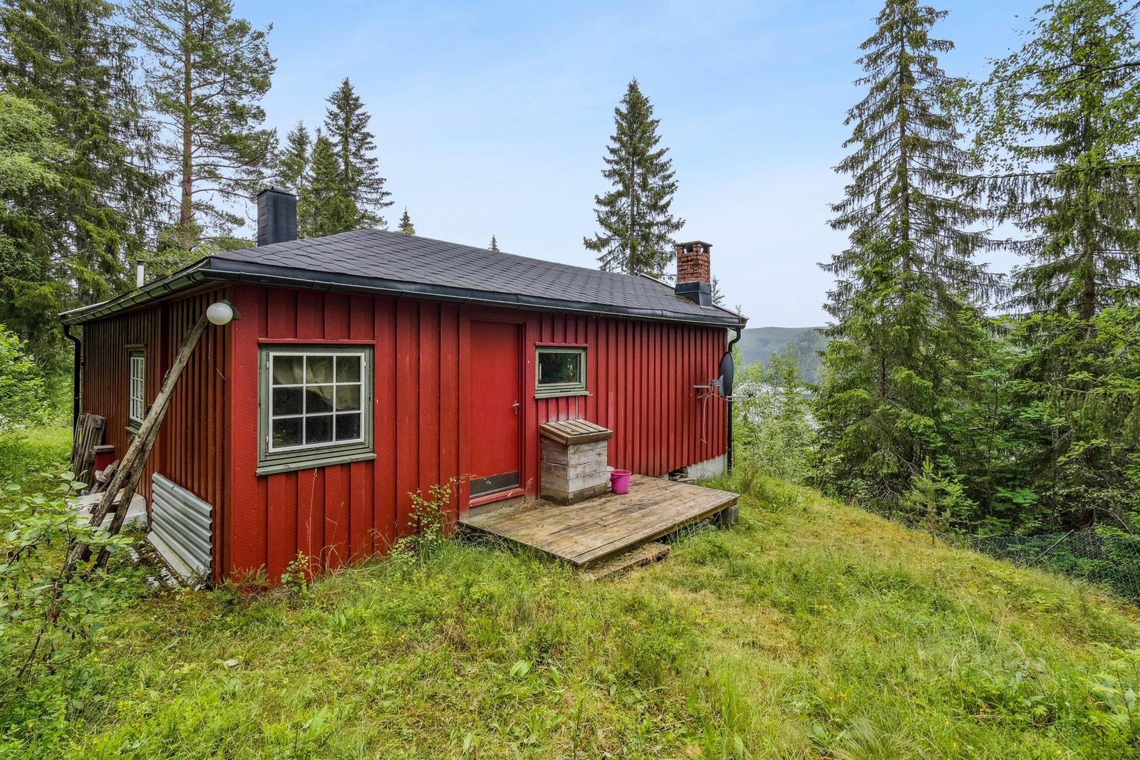 Hytten har to innganger. En hoveddør på fremsiden og en bakdør til hagen og uthuset i bakkant Galleribilde