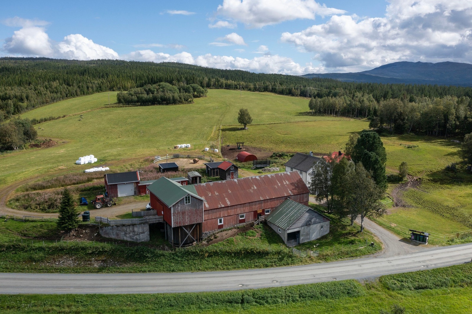 Dronefoto av våningshus, fjøs/driftsbygning, verksted/vognskjul, kårbolig, stabbur, hønsehus og kanin hus. Galleribilde