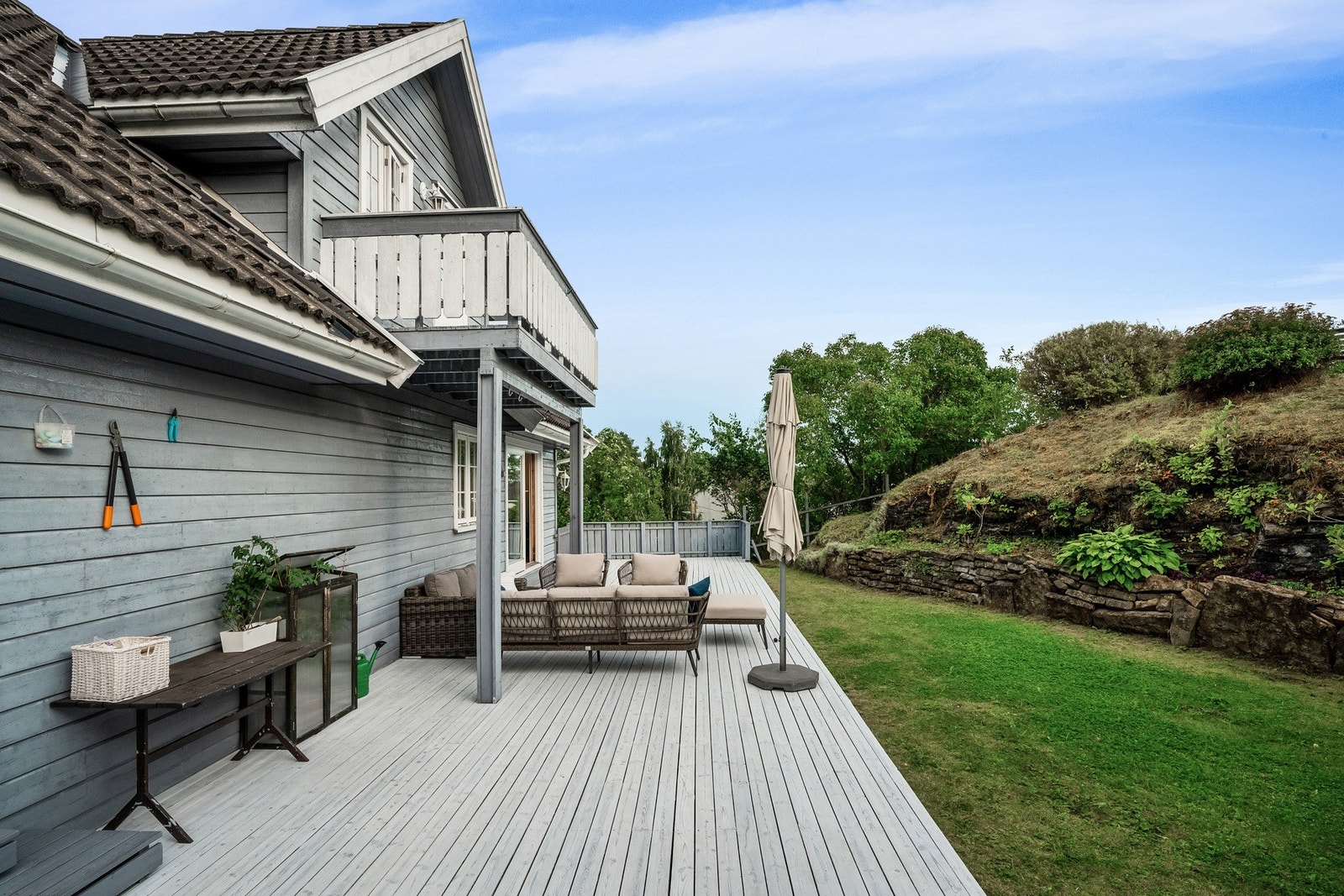 Stor terrasse på 61 kvm mot delvis kupert hage/tomt Galleribilde