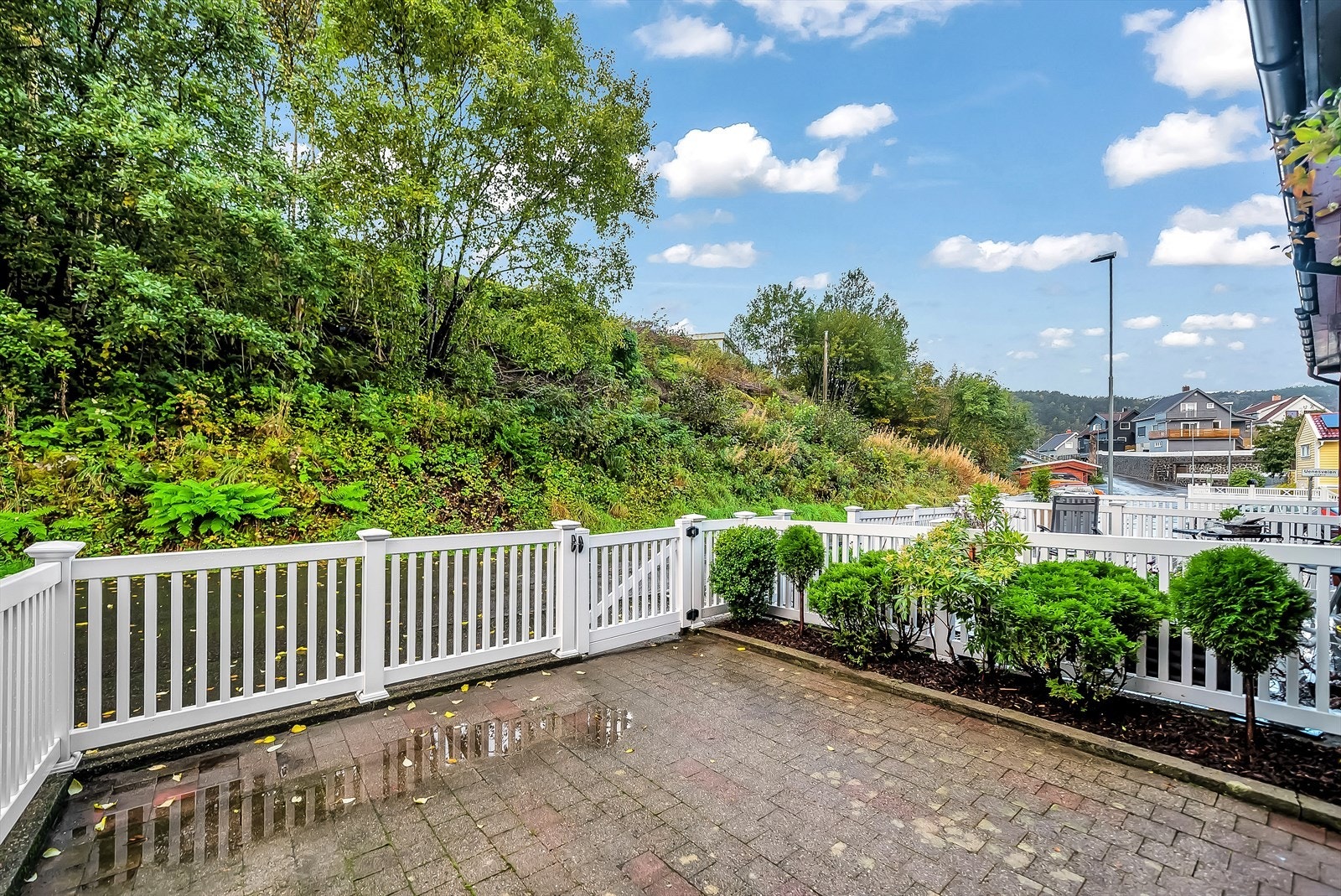 Ved inngangsparti er det koselig, innegjerdet uteområde belagt med brostein og prydbusker. Galleribilde