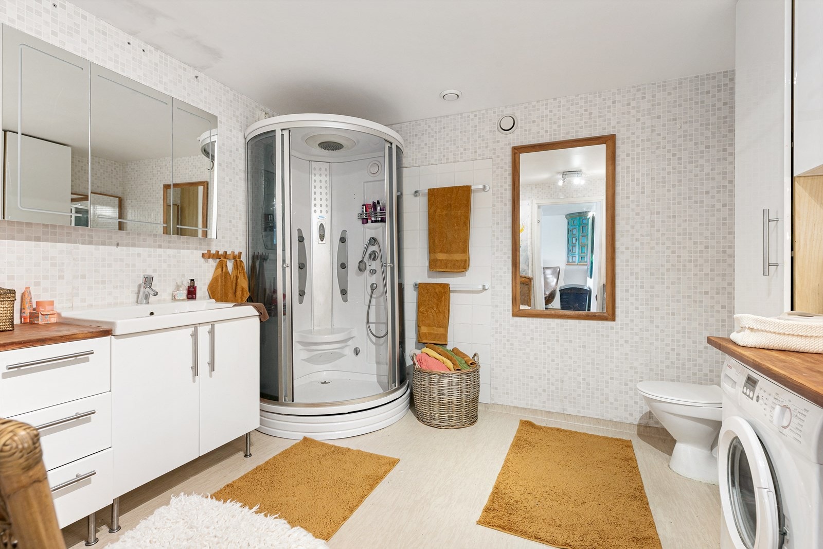 Romslig bad med lyse fliser på veggene. Galleribilde