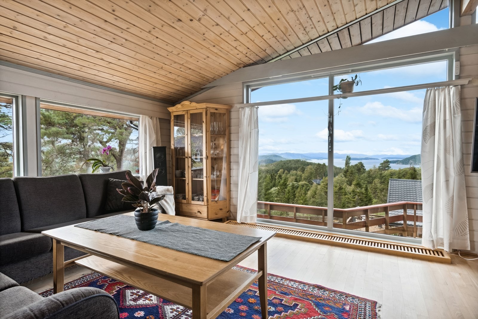 Stue med åpen himling og store vinduer med fin utsikt mot Namsenfjorden. Galleribilde