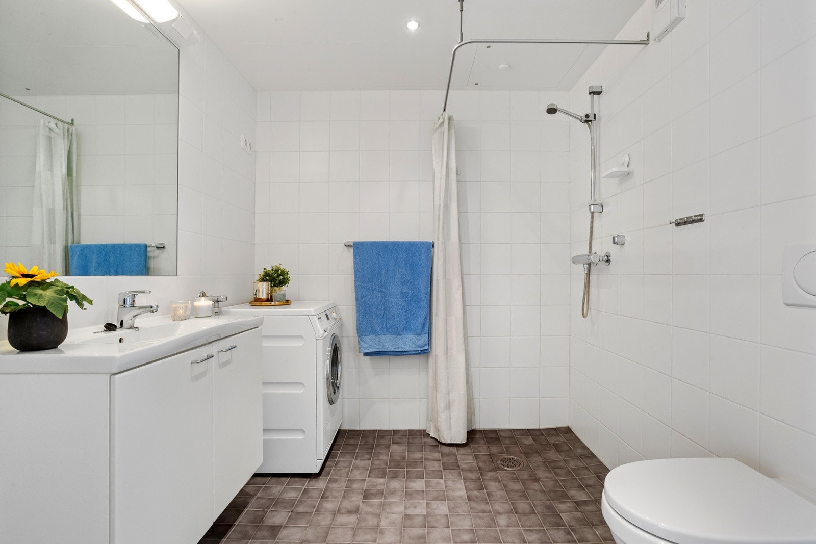 Bad fra byggeår med lys innredning, downlights og stort speil Galleribilde