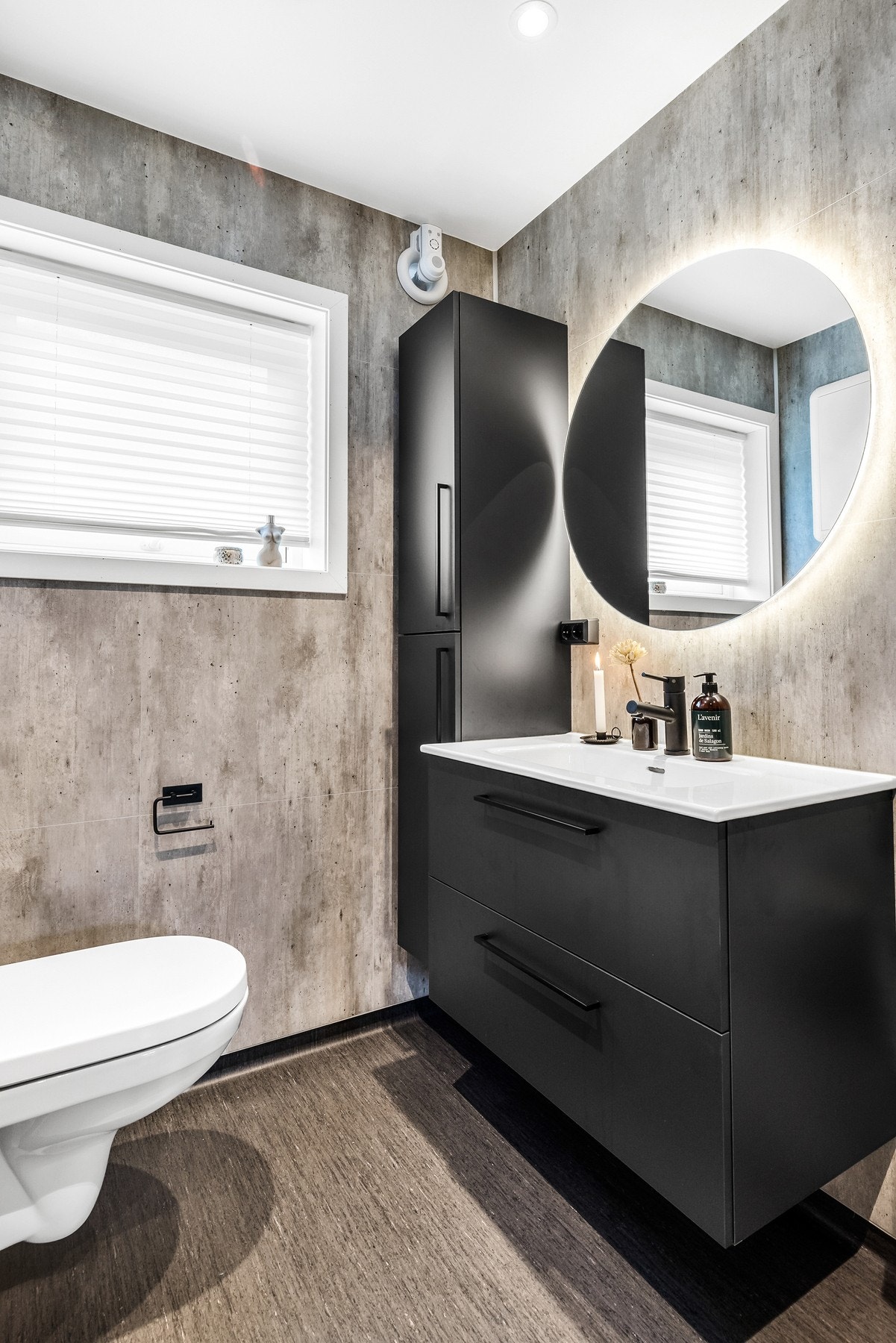 Badet er innredet med baderomsinnredning med heldekkende servant, veggmontert toalett og dusjhjørne/-dører Galleribilde
