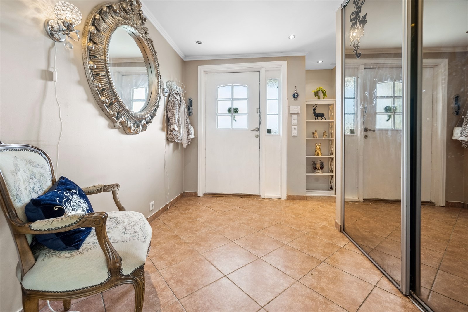 Her ønskes du velkommen inn i flislagt entré med varmekabler. Det er god plass til oppbevaring av ytterklær og sko i stort garderobeskap med skyvedører av speil. Galleribilde